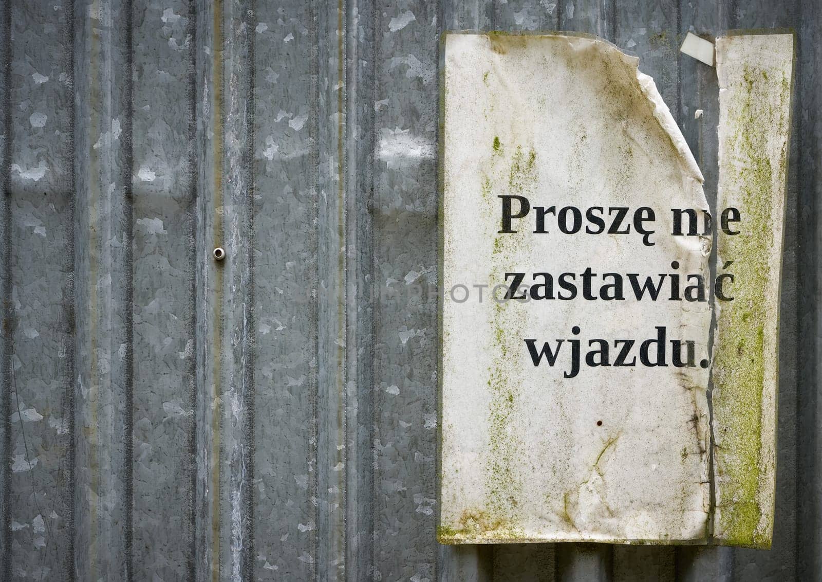 Sign with the inscription proszę nie zastawiać wjazdu on the door of a construction container at a construction site in Poland white copy space on left side. Translation: please do not block the entrance