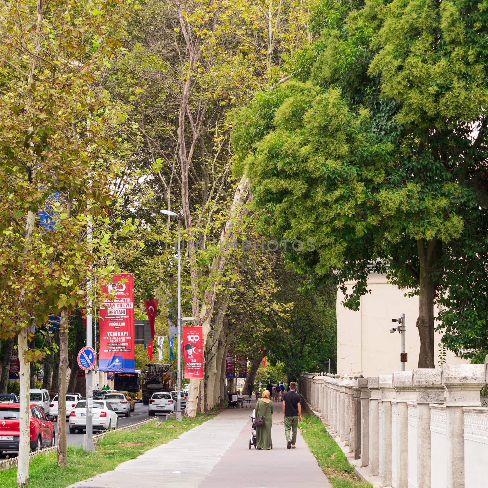 Istanbul, Turkey - August 31, 2022: Pedestrians walking in a passage with huge green trees in Gulhane Park in summer time, Sultan Ahmet district