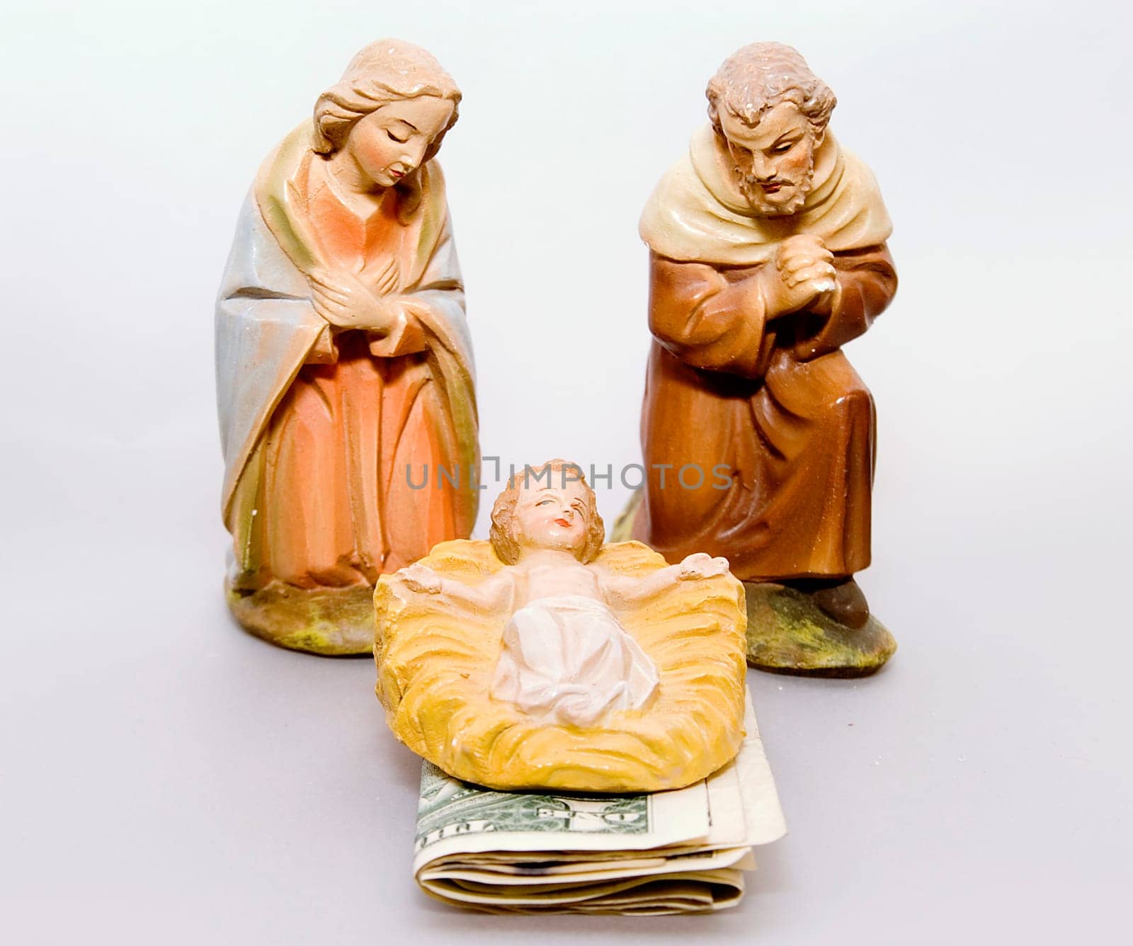 Commercialism vs Christmas, Mary and Joseph looking at baby Jesus, with money under the manger.