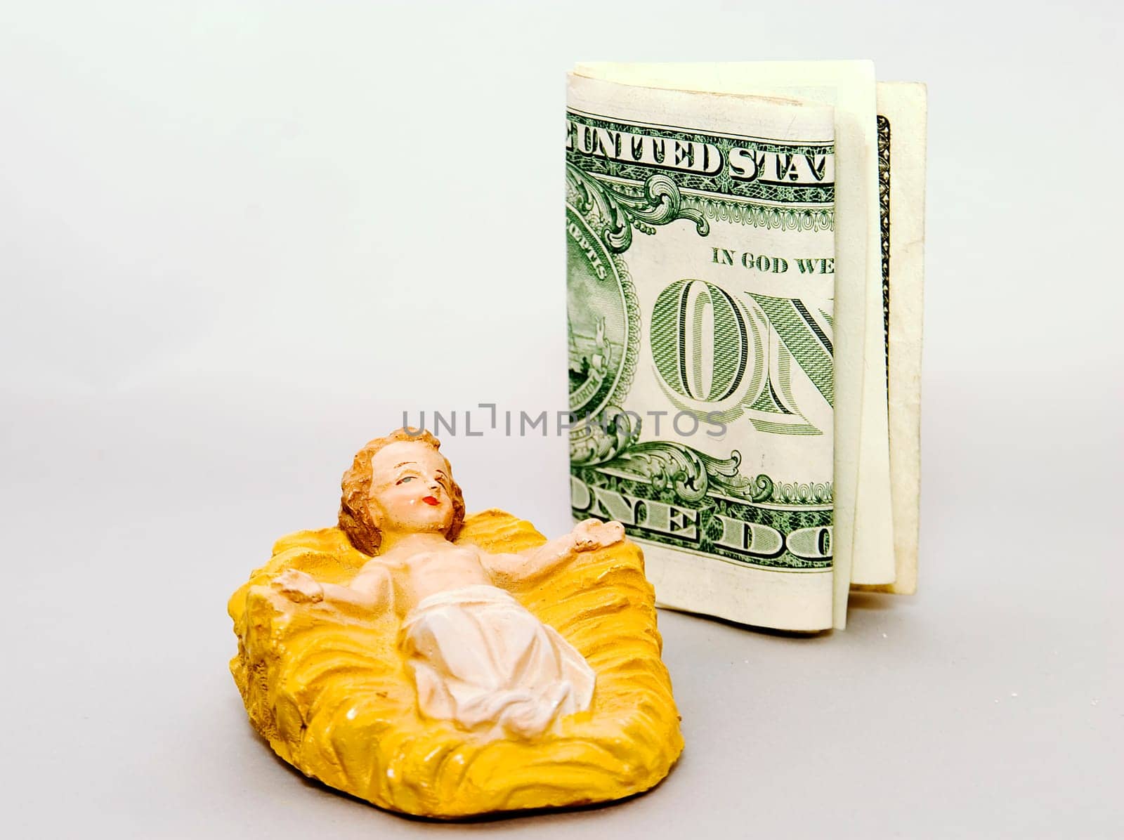 Commercialism vs Christmas a bill beside the Christ Child.
