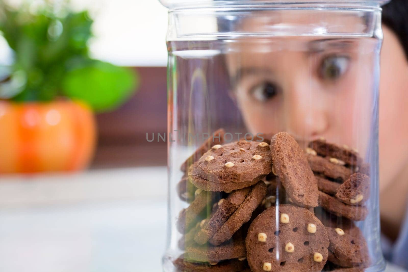 little boy looking at cookies in a jar