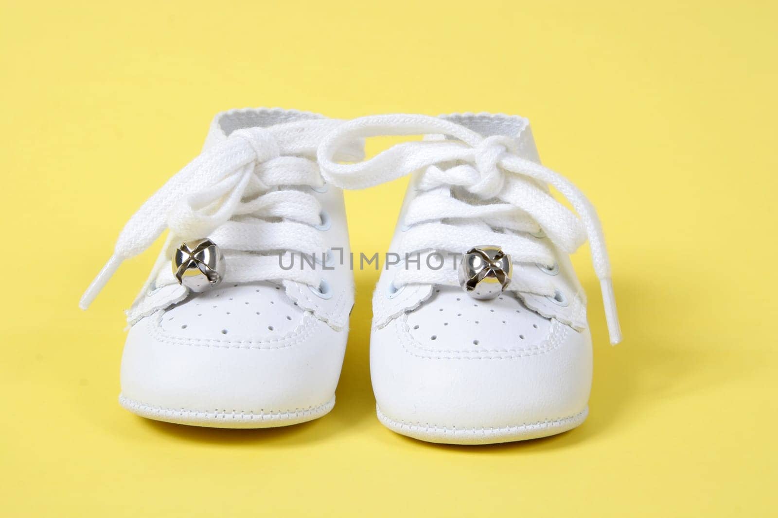 Little Baby shoes together on yellow background