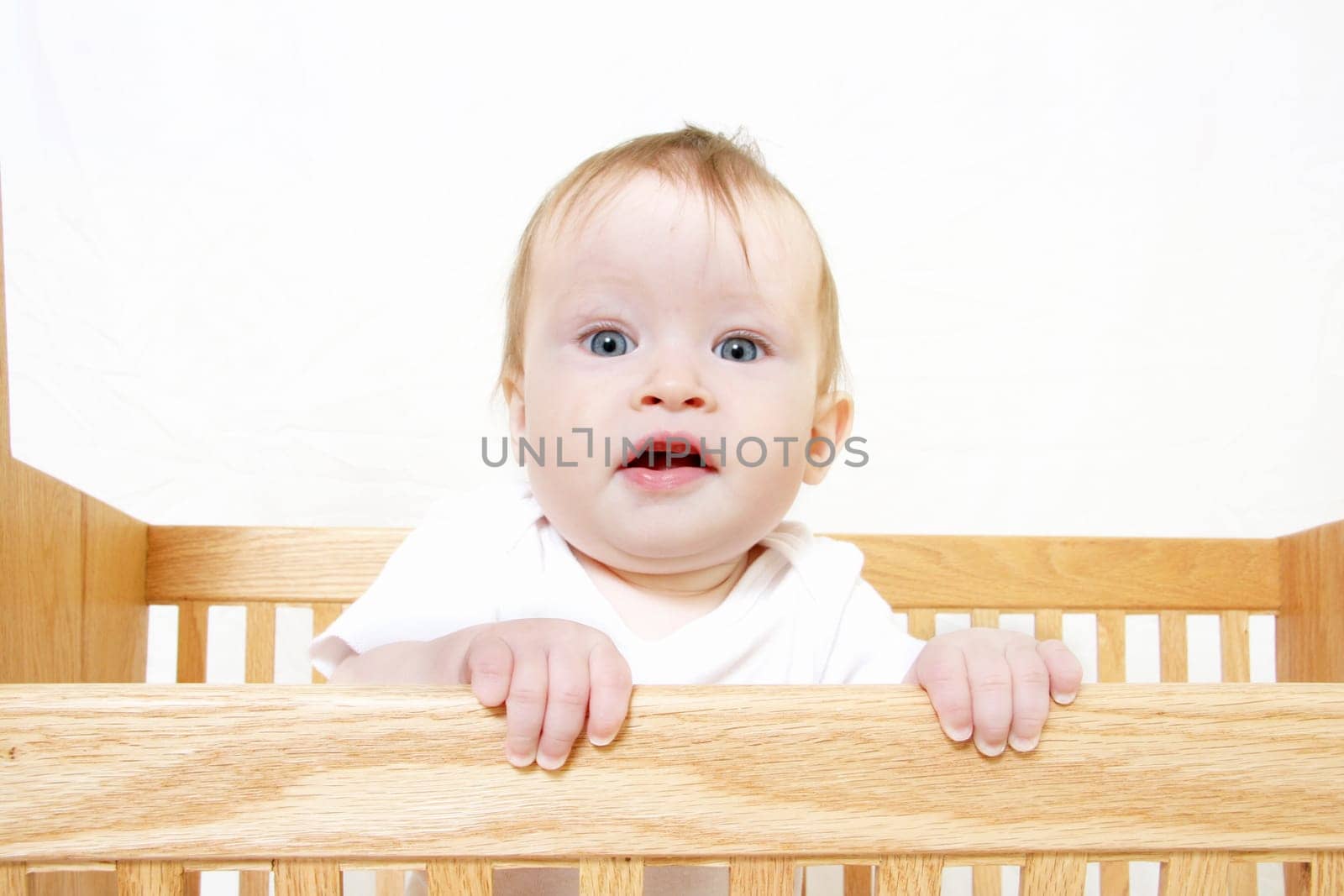 Little Baby holding onto side of crib
