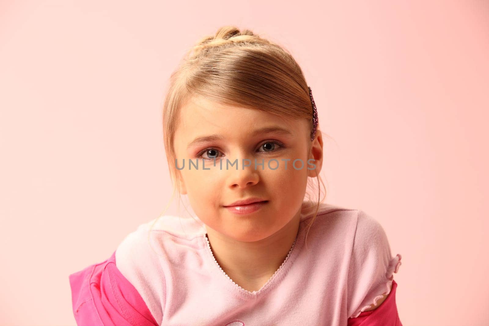 The beautiful girl on a pink background in red trousers and a jacket