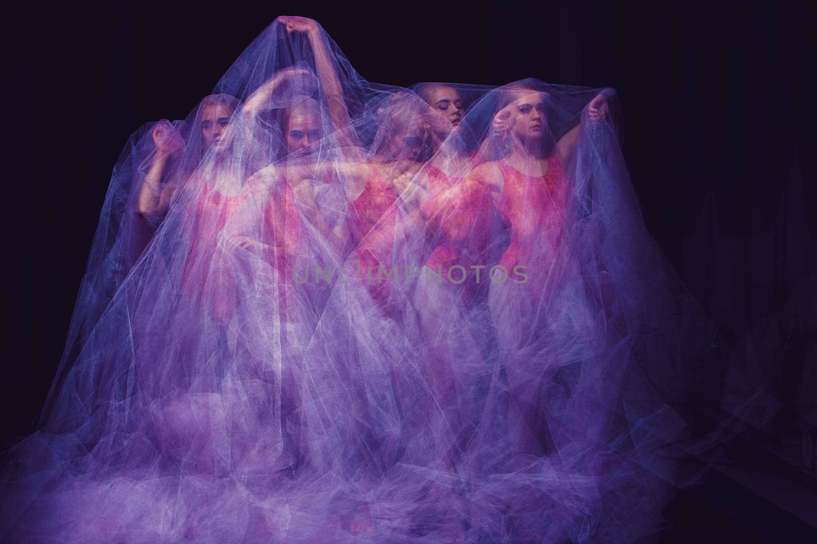 photo as art - a sensual and emotional dance of beautiful ballerina through the veil on a dark background. A stroboscopic image of the one model