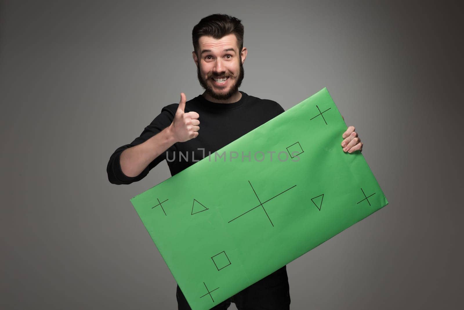 The smiling man as businessman with green panel on gray background. Positive human emotions and advertising of something