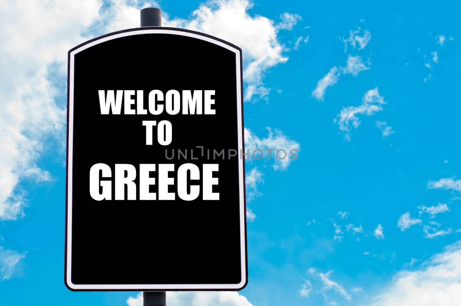 Black road sign with greeting message WELCOME TO GREECE isolated over clear blue sky background with available copy space. Travel destination concept  image