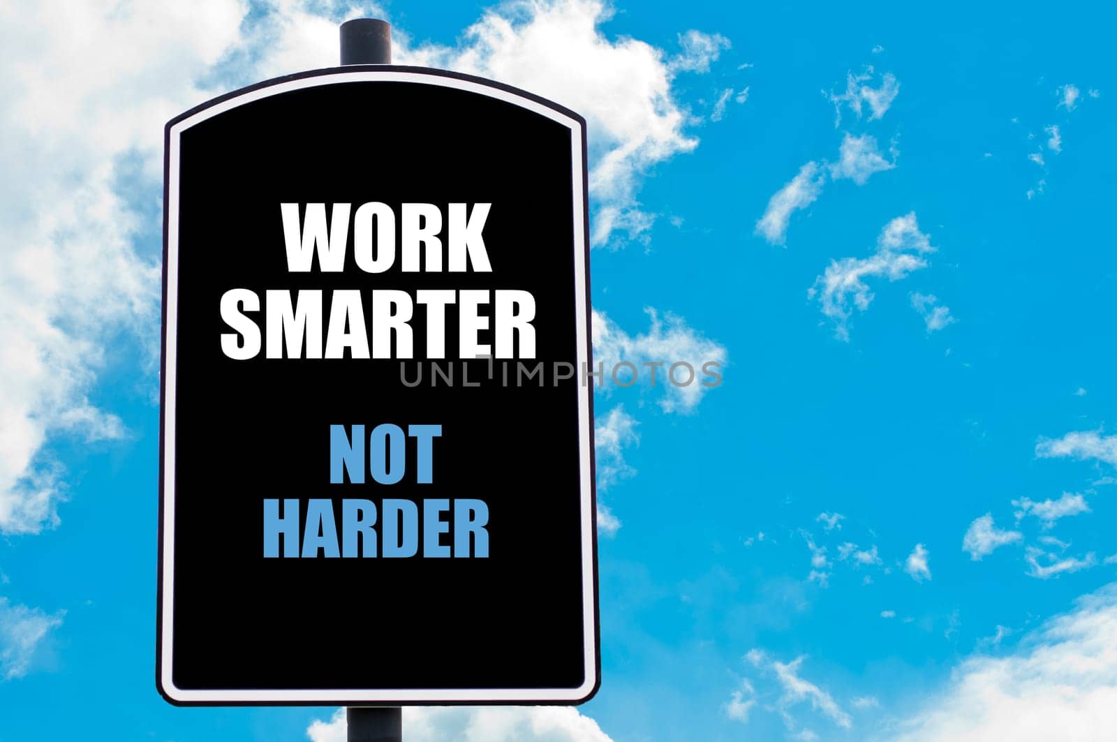 WORK SMARTER NOT HARDER  motivational quote written on road sign isolated over clear blue sky background with available copy space. Concept  image