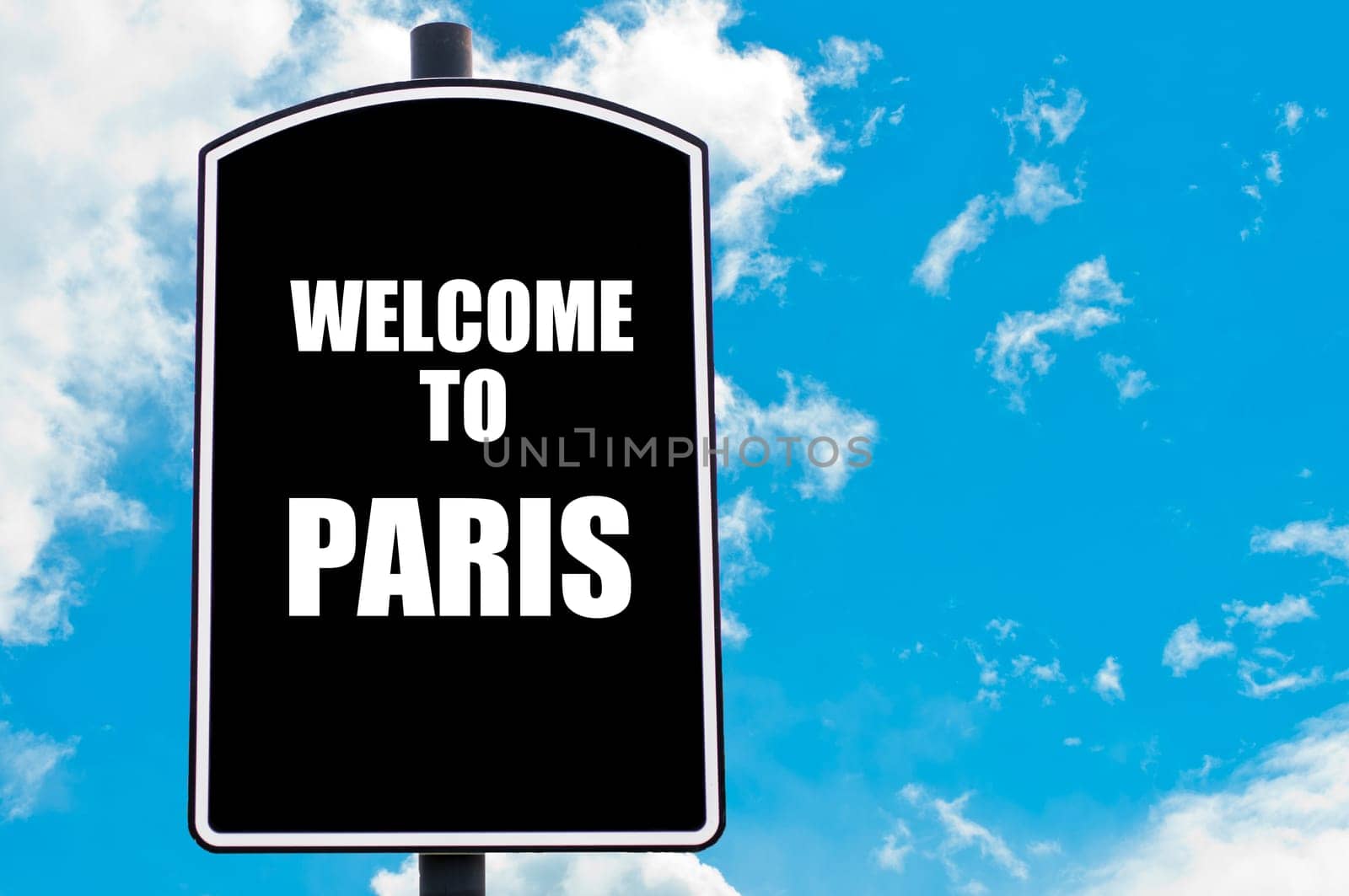 Black road sign with greeting message WELCOME TO PARIS isolated over clear blue sky background with available copy space. Travel destination concept  image