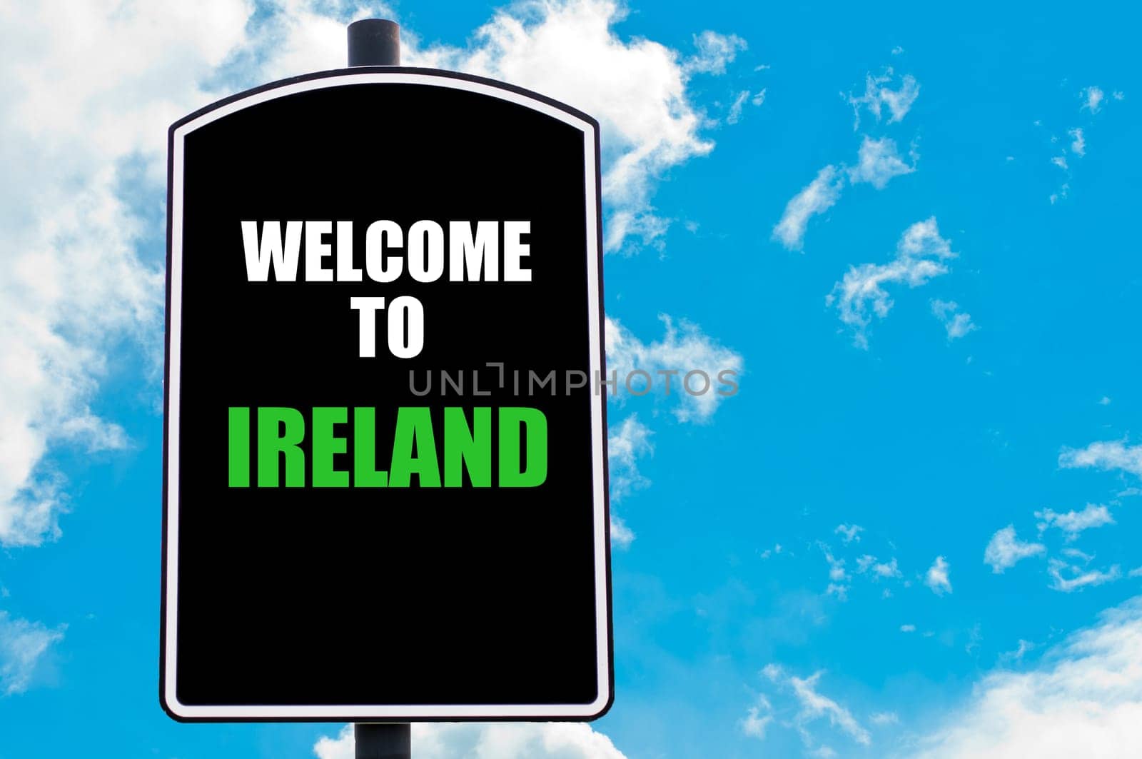 Black road sign with greeting message WELCOME TO IRELAND isolated over clear blue sky background with available copy space. Travel destination concept  image