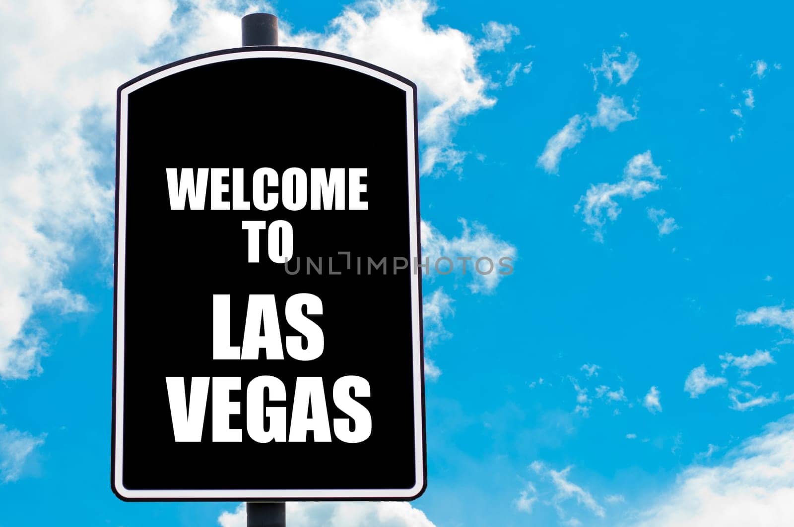 Black road sign with greeting message WELCOME TO LAS VEGAS isolated over clear blue sky background with available copy space. Travel destination concept  image