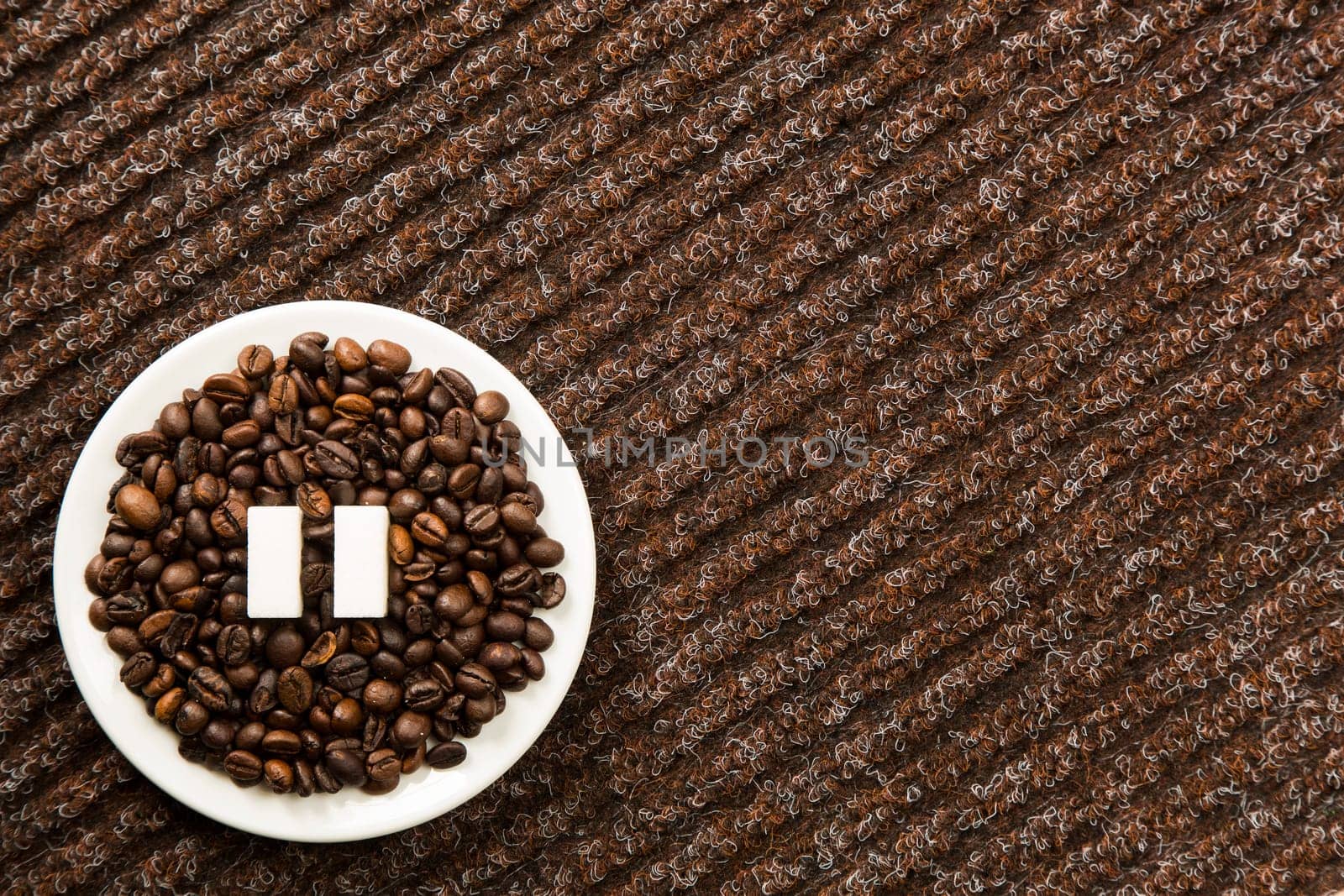 Concept of a coffee pause, coffee beans arranged in a circle with sugar cubes.