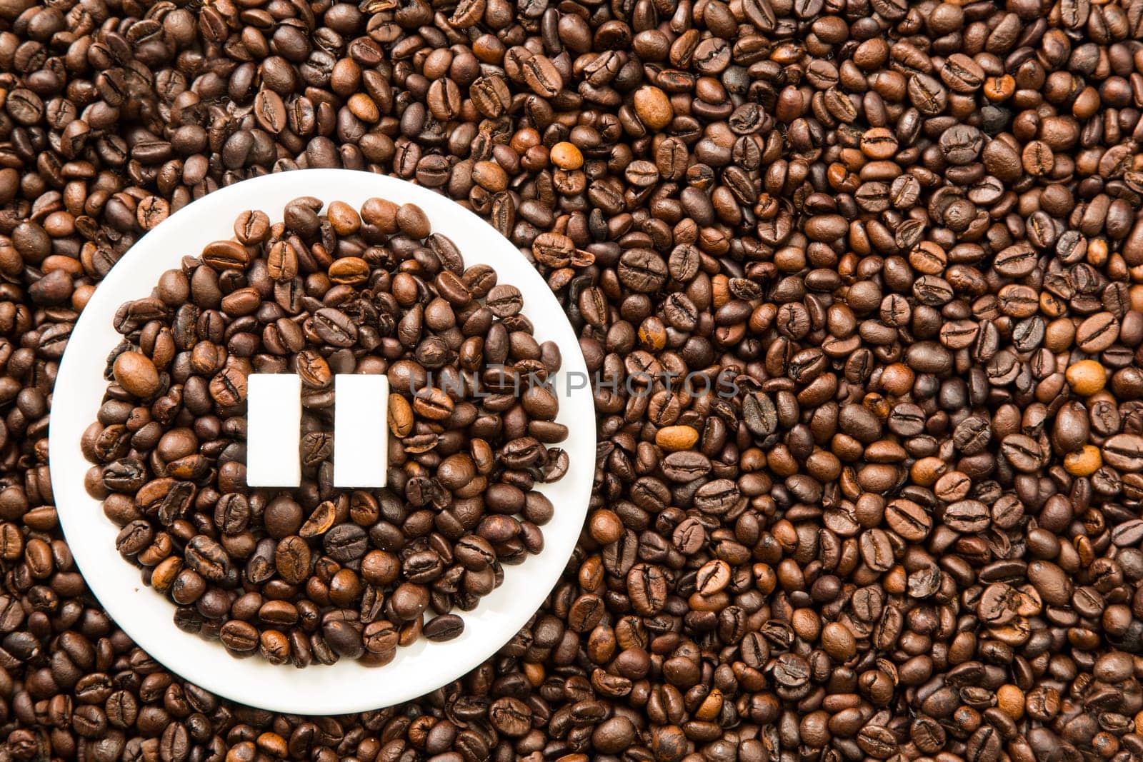 Concept of a coffee pause, coffee beans arranged in a circle with sugar cubes.