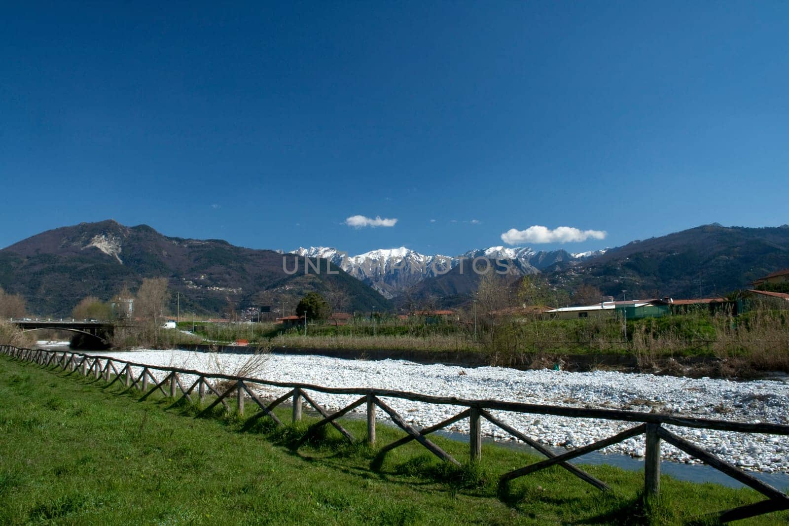 view of a portion of the fence and the river with a backdrop of the Apuan Alps
