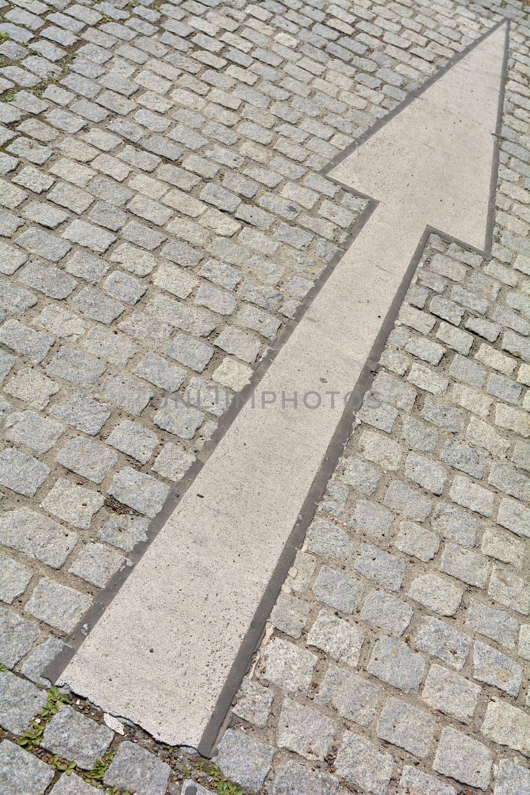 Arrow on a road with cobblestones