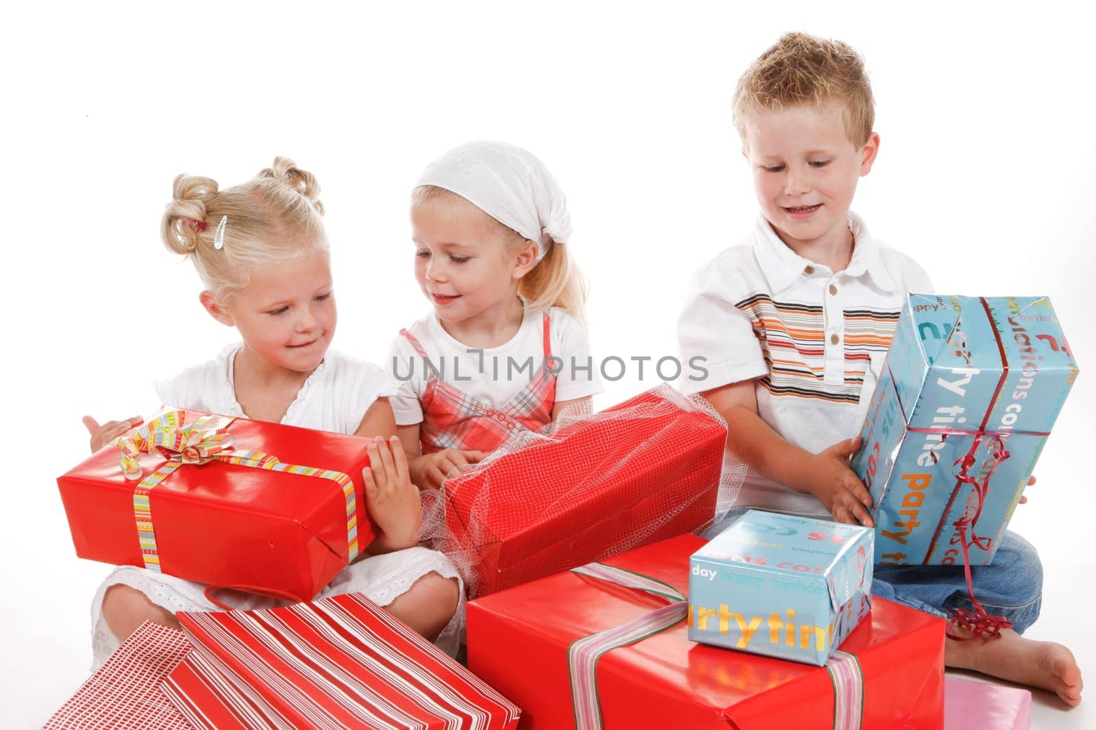three cute children celebrating special occasion with several gifts