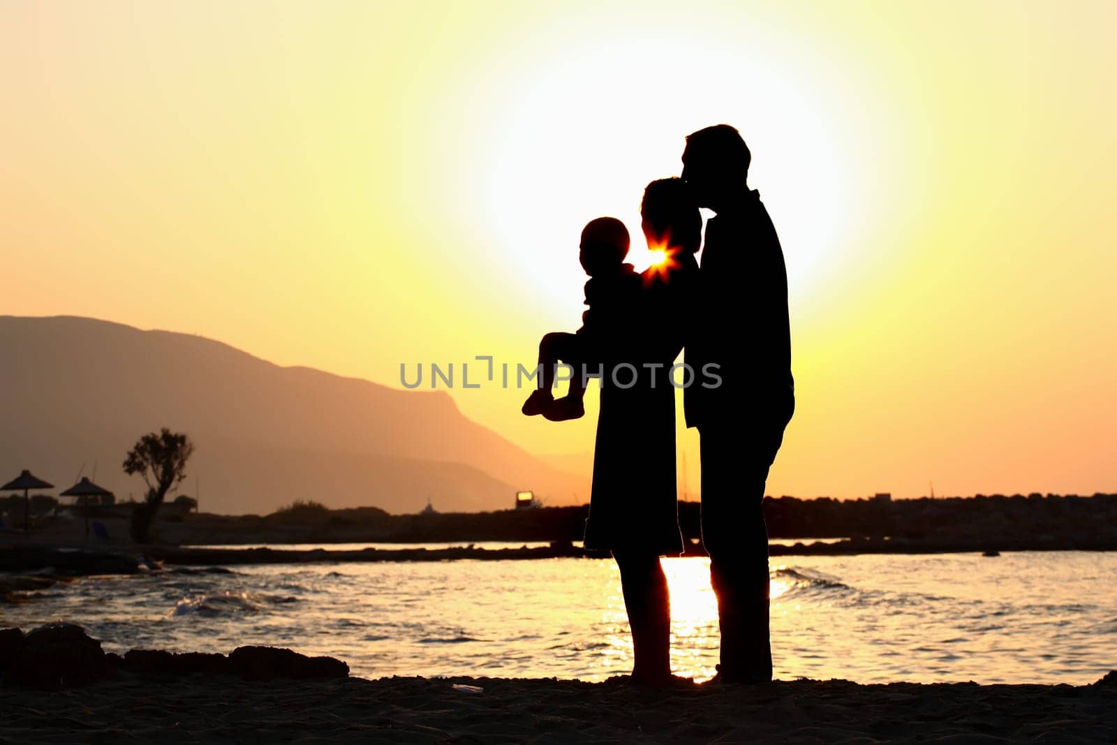 silhouette of a happy family of three on the beach