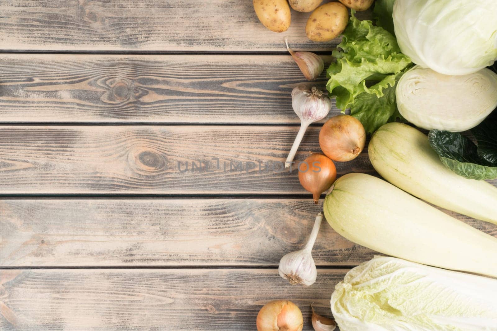 Vertical row of fresh farm vegetables on wooden table, top view. Seasonal foodstuffs sorting. Nitrate free food or healthy diet concept. Objects layout. Planking. Cooking ingredients. Place for text.