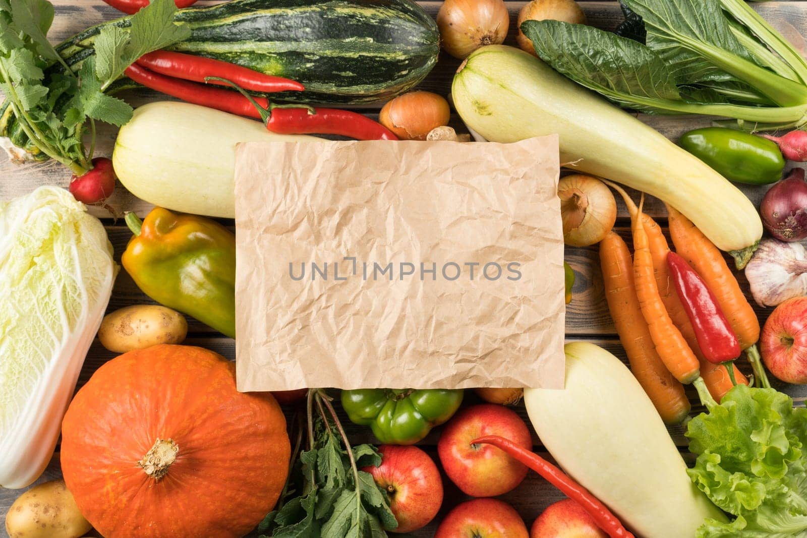 Sheet of paper on mix of different fresh farm vegetables and fruits, top view. Table full of organic ripe seasonal harvest. Nitrate free food or healthy diet concept. Balanced nutrition. Cooking.