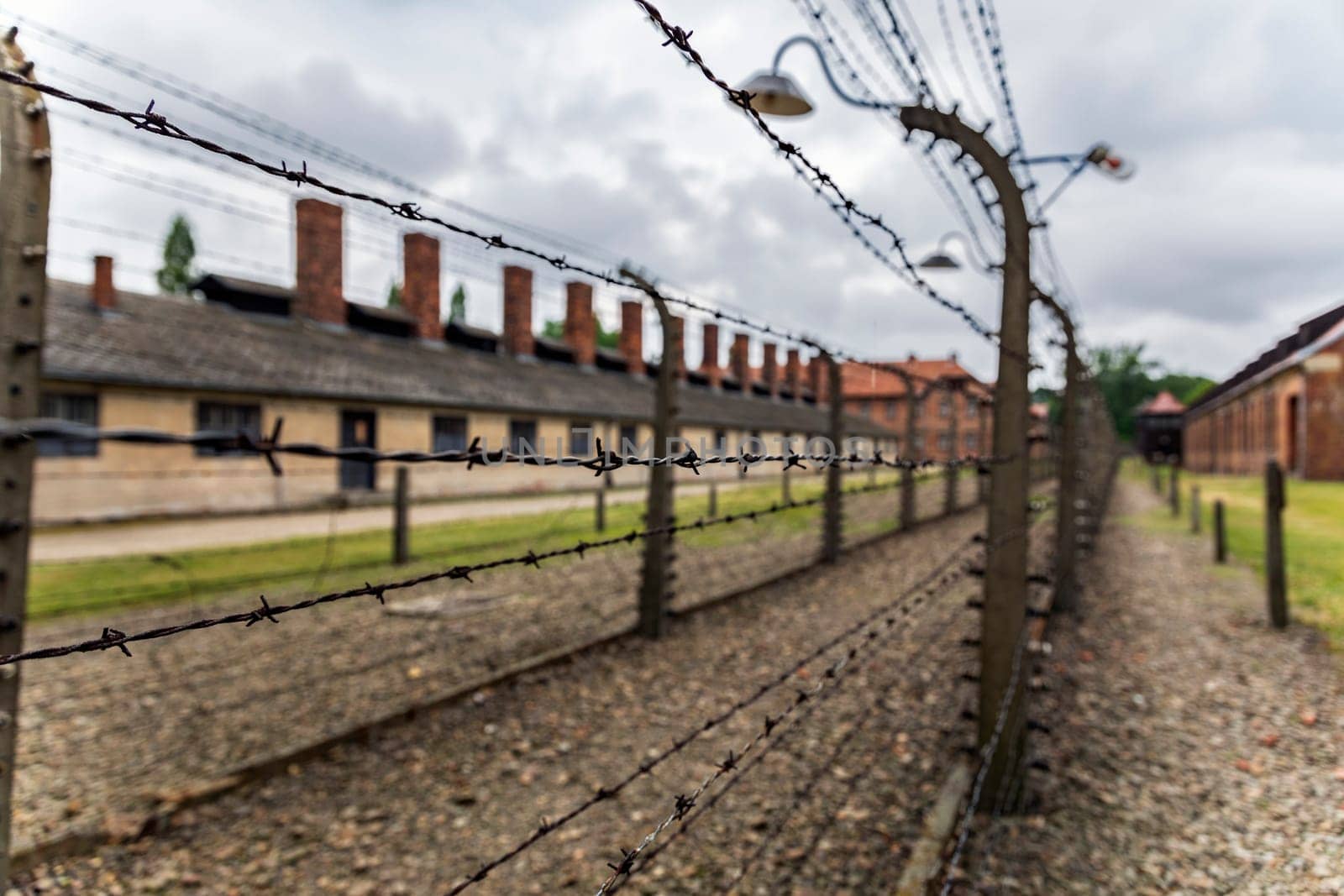 Barracks for prisoners behind barbed wire fence in Auschwitz Nazi concentration camp Poland