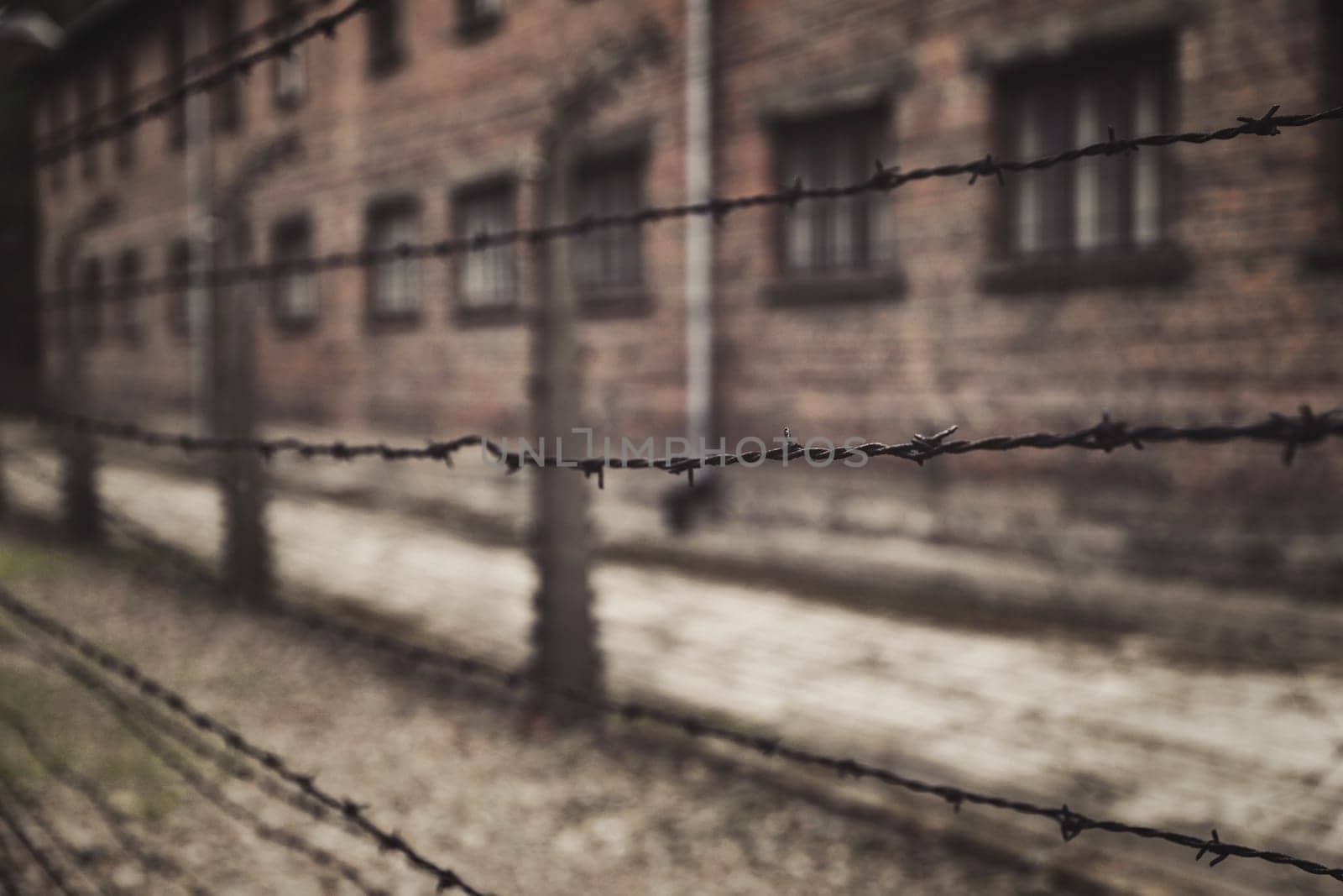 Barracks for prisoners behind barbed wire fence in Auschwitz Nazi concentration camp Poland