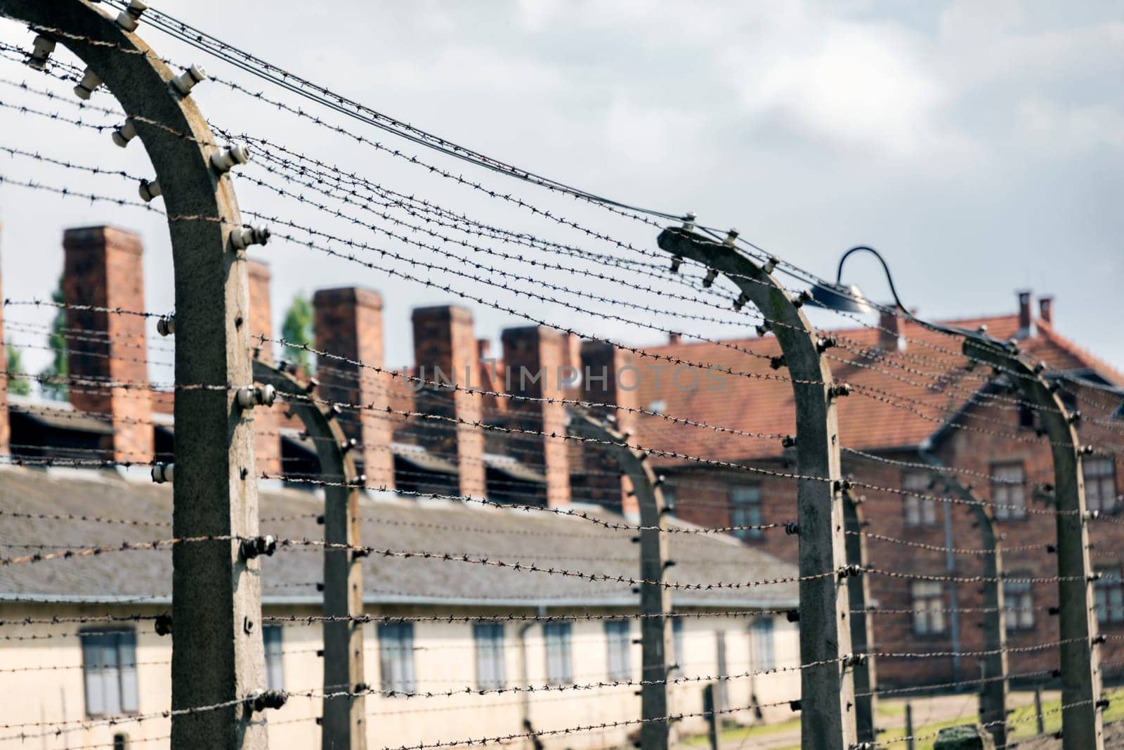 Barracks for prisoners behind barbed wire fence in Auschwitz Nazi concentration camp Poland