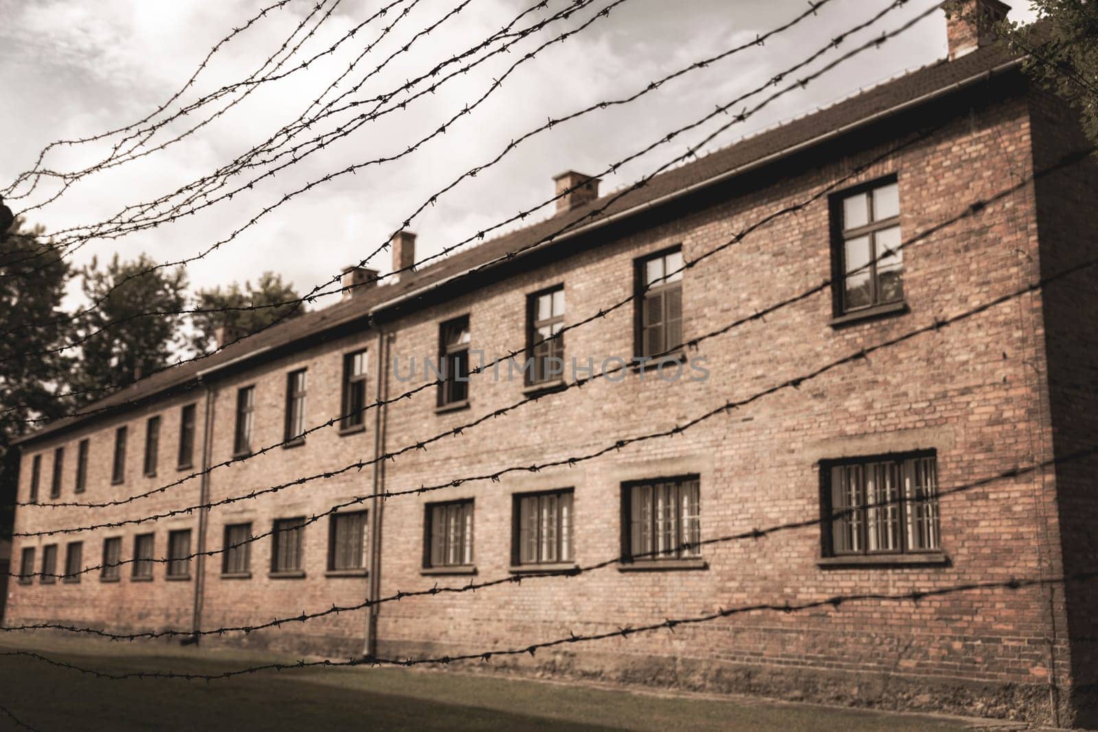 Barracks for prisoners behind barbed wire fence in Auschwitz Nazi concentration camp Poland