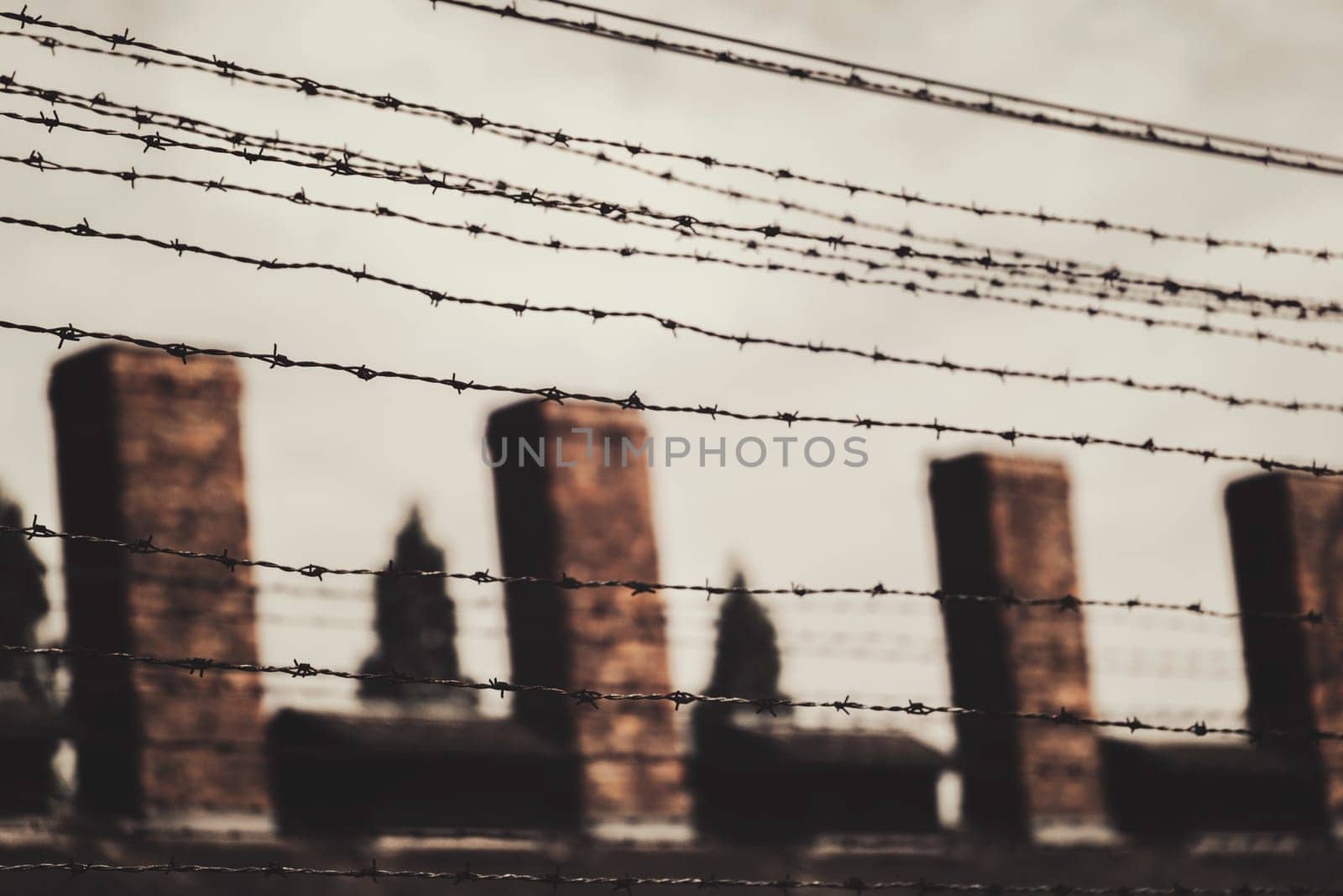 Barracks for prisoners behind barbed wire fence in Auschwitz Nazi concentration camp Poland