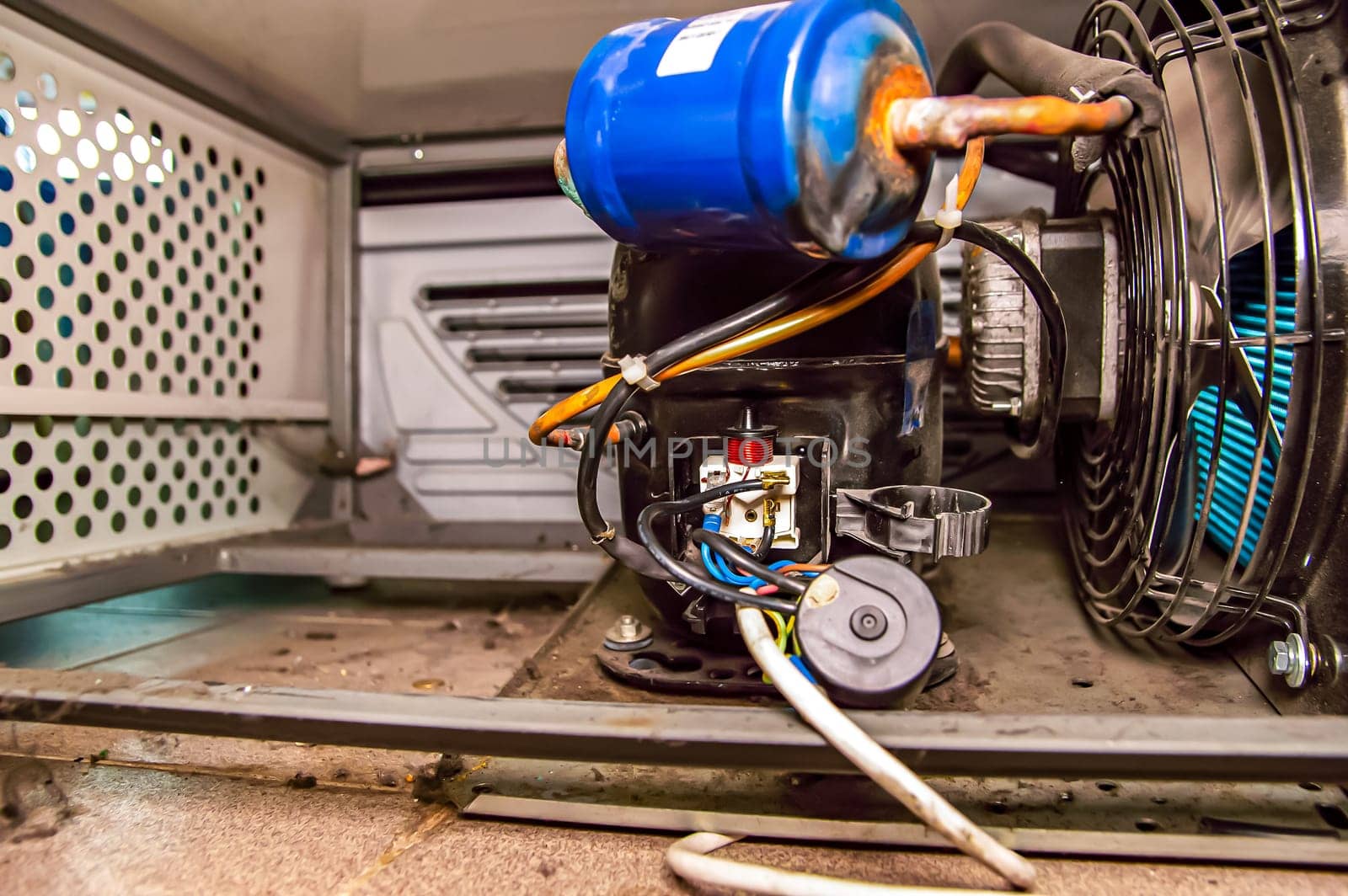 Electric starting relay for the compressor of the refrigeration unit motor. Electromagnetic coil of the starting relay. Refrigeration unit compressor. Refrigerator repair. Repair of air conditioners.