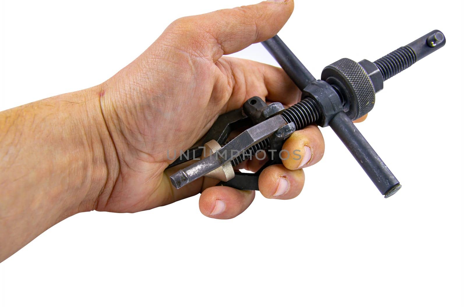 A bearing puller is a tool in the hands of a specialist. Hand working tool. Bearing puller. Man's hand. Car repair. Repair of washing machines. Industrial equipment. Repair shop.