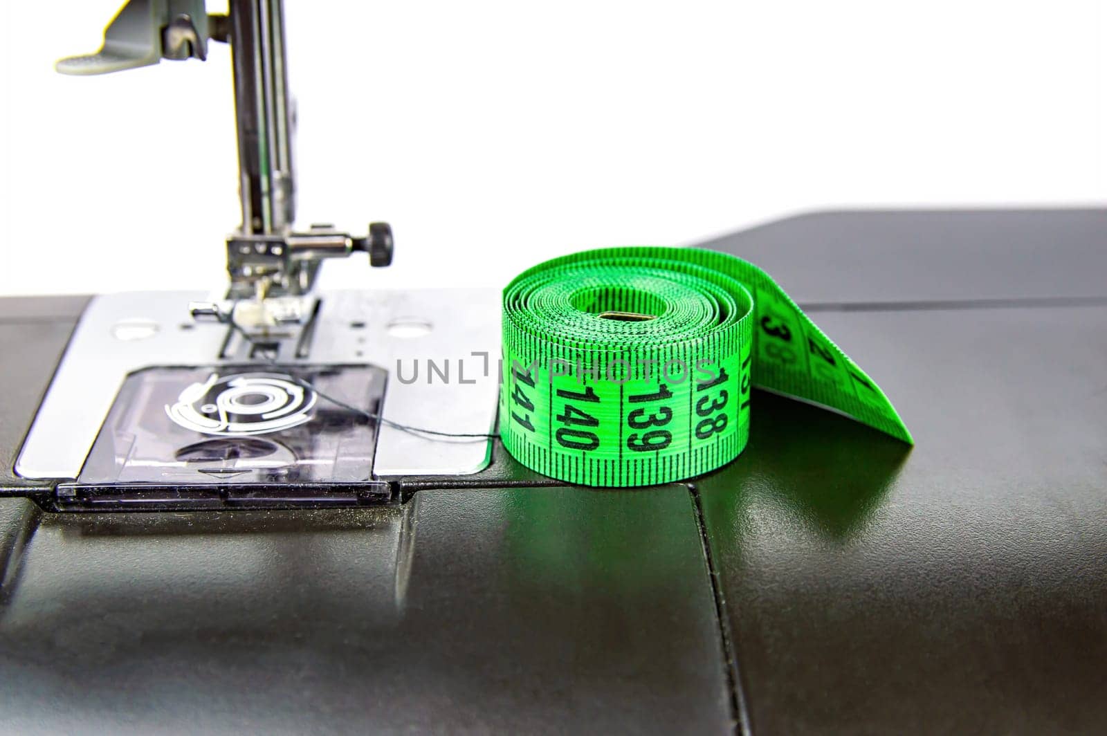 Tailors measuring meter on a sewing machine. Measuring tool. Seamstress meter. Sewing machine. Clothing size. Seamstress equipment. Working profession.