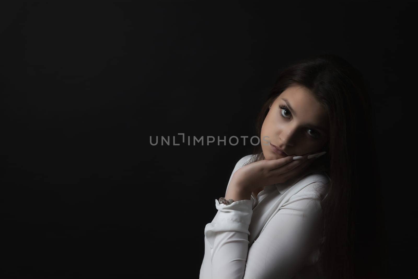 Sad girl in low key portrait. Horizontally.