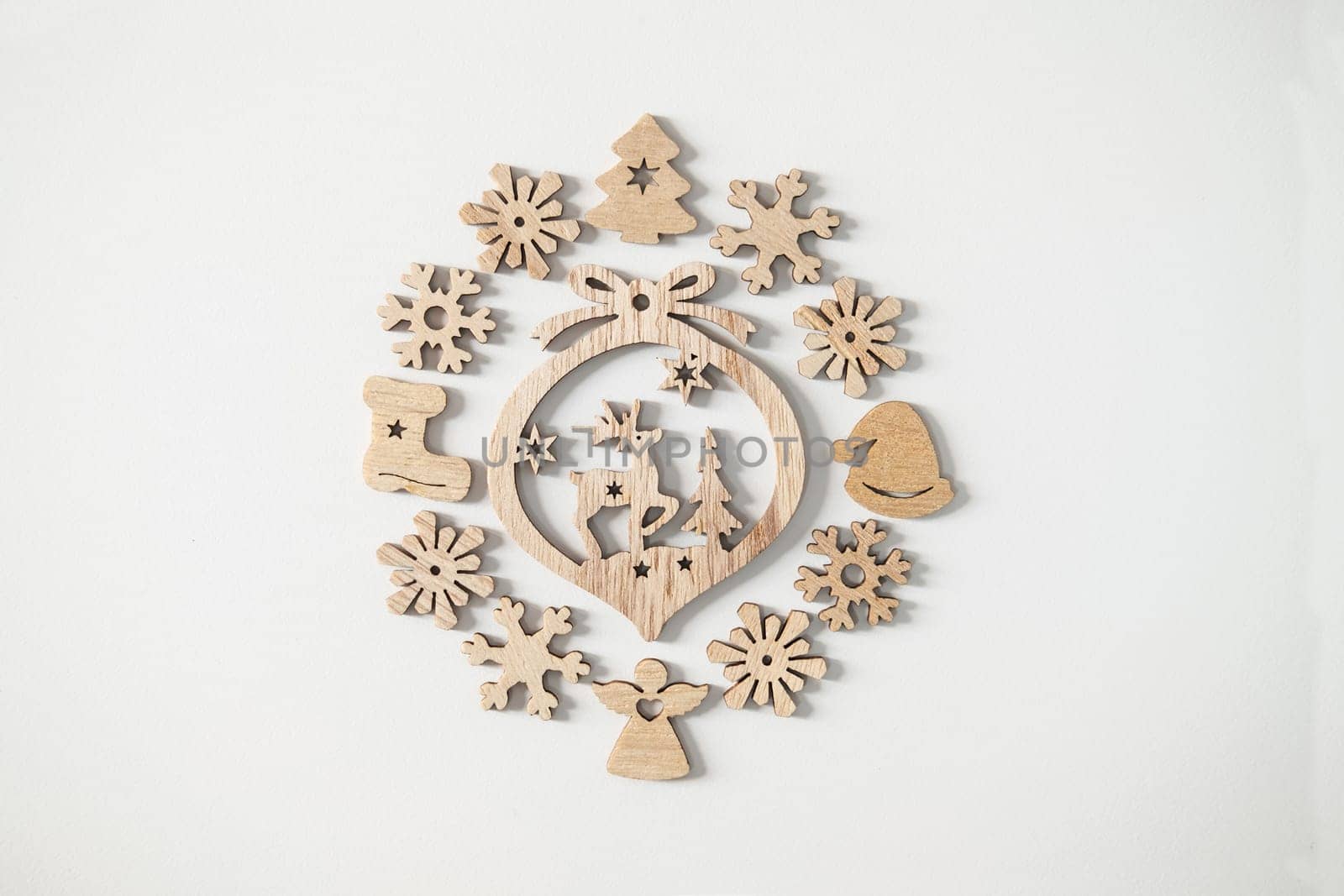 Christmas winter festive ornament. Wooden Christmas decoration on white background. Christmas holiday party decoration. Minimal holiday greeting season. Selective focus.