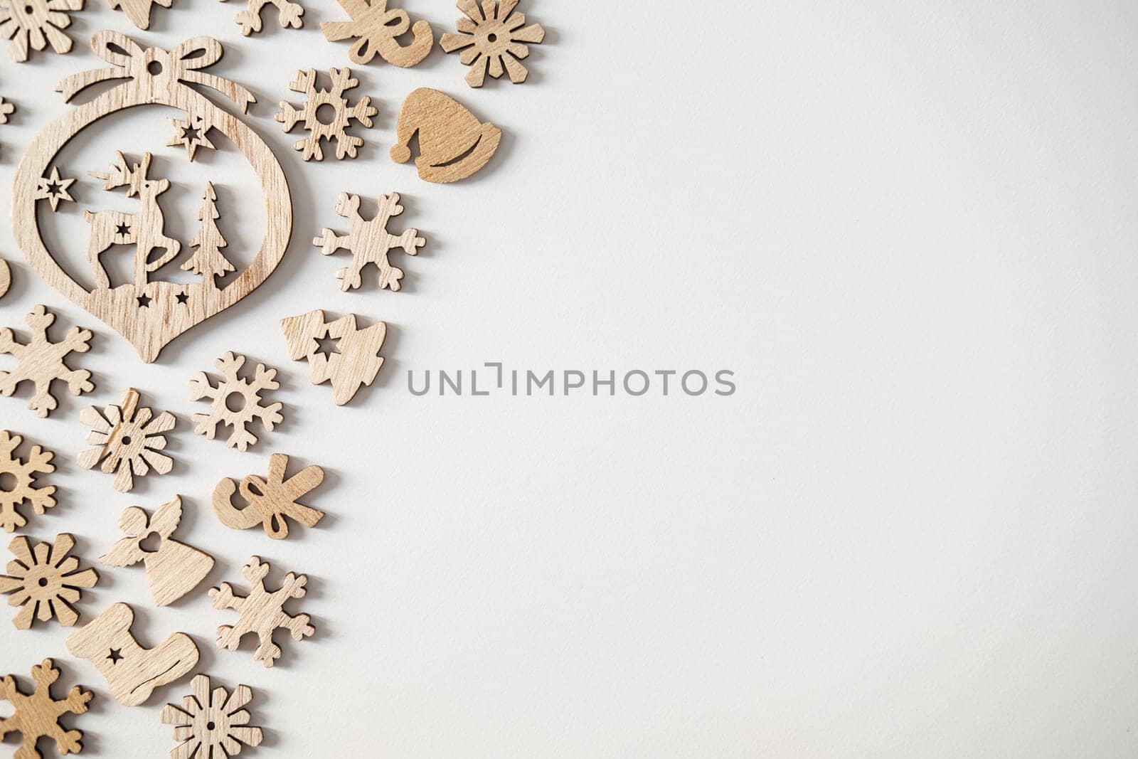 Christmas winter festive ornament. Wooden Christmas decoration on white background. Christmas holiday party decoration. Minimal holiday greeting season. Selective focus.