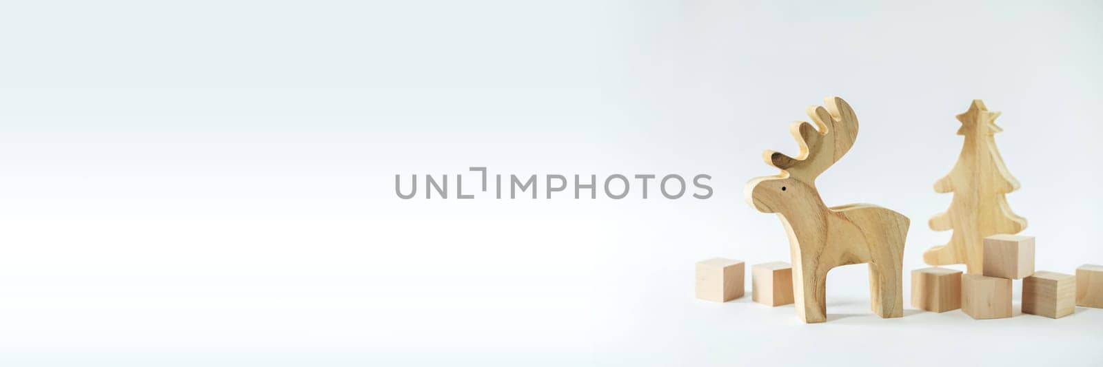 Christmas winter festive ornament. Wooden reindeer, pine tree and gift boxes decoration on white background. Christmas holiday party decoration. Minimal holiday greeting season. Panoramic banner.