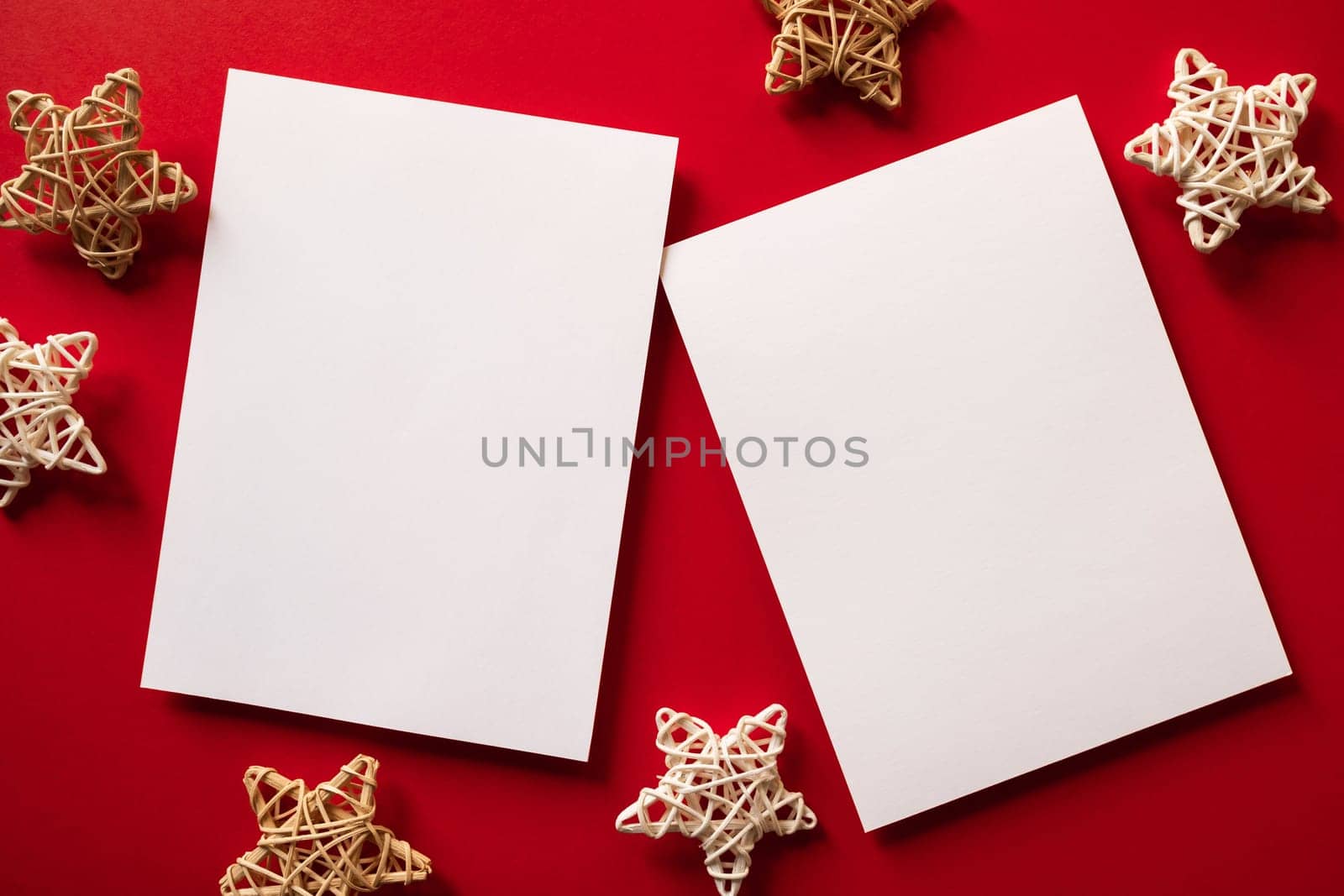Christmas winter festive ornament. Blank paper cards with wooden decoration on red background. Minimal decoration. Invitation Christmas holiday party. Flat lay, top view, copy space.