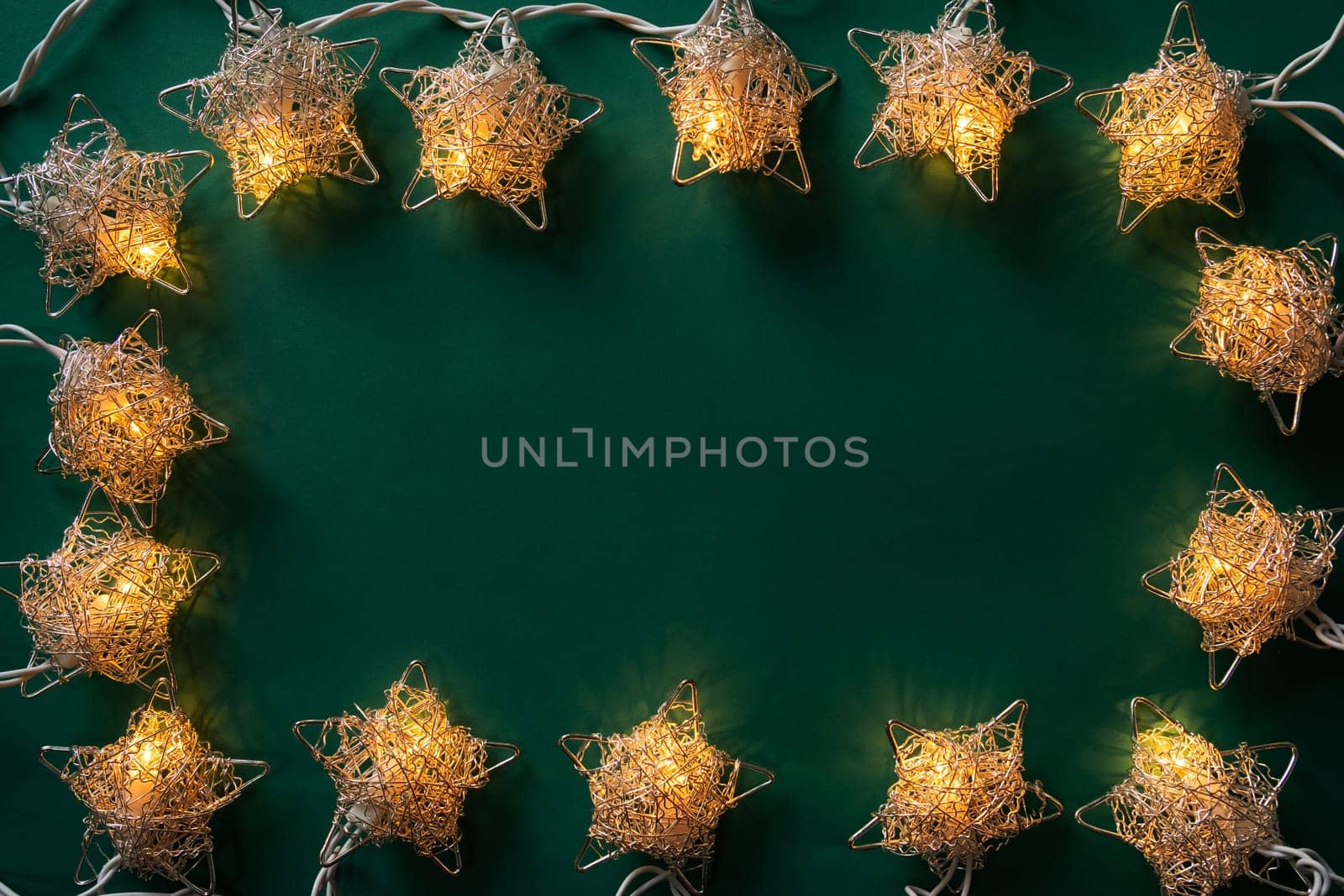 Christmas winter festive ornament. Christmas lights frame on green background. Invitation Christmas holiday party. Flat lay, top view, copy space.