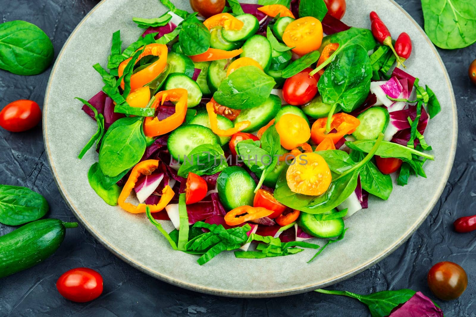 Spring salad of tomatoes, cucumbers, peppers and lettuce.