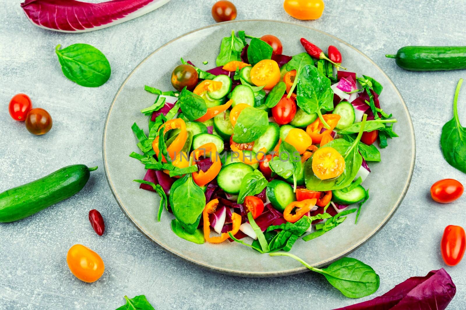 Spring salad of tomatoes, cucumbers, peppers and lettuce.