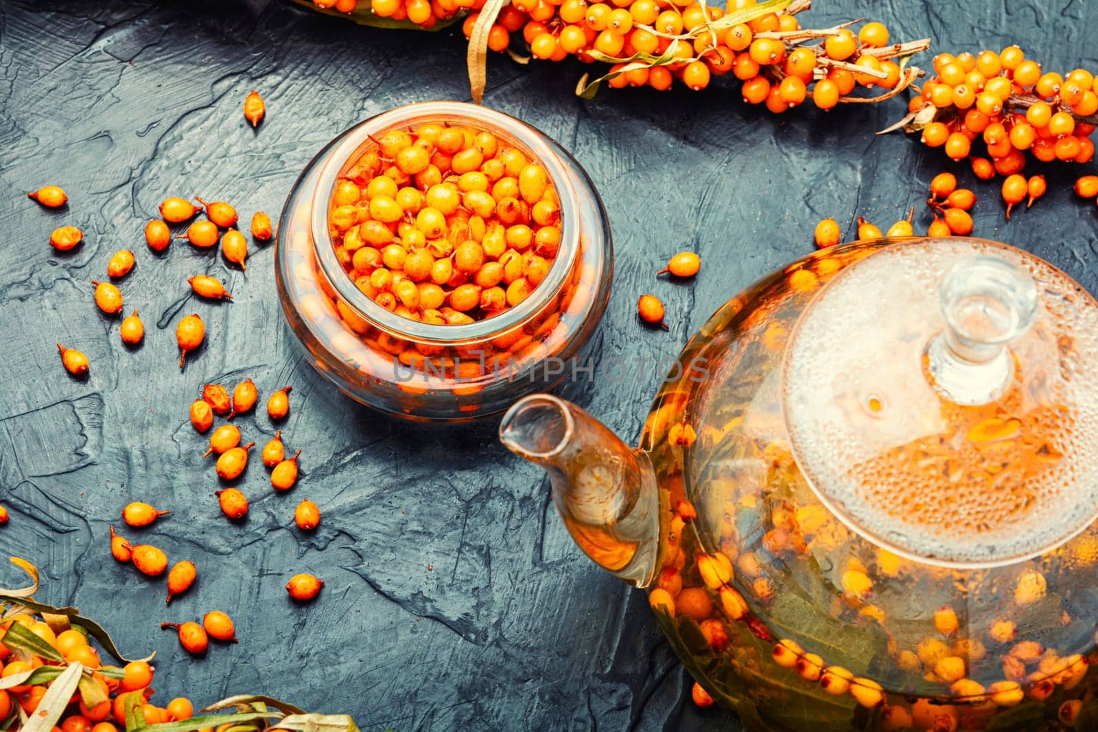 Salubrious autumn drink, tea with fresh sea buckthorn berries