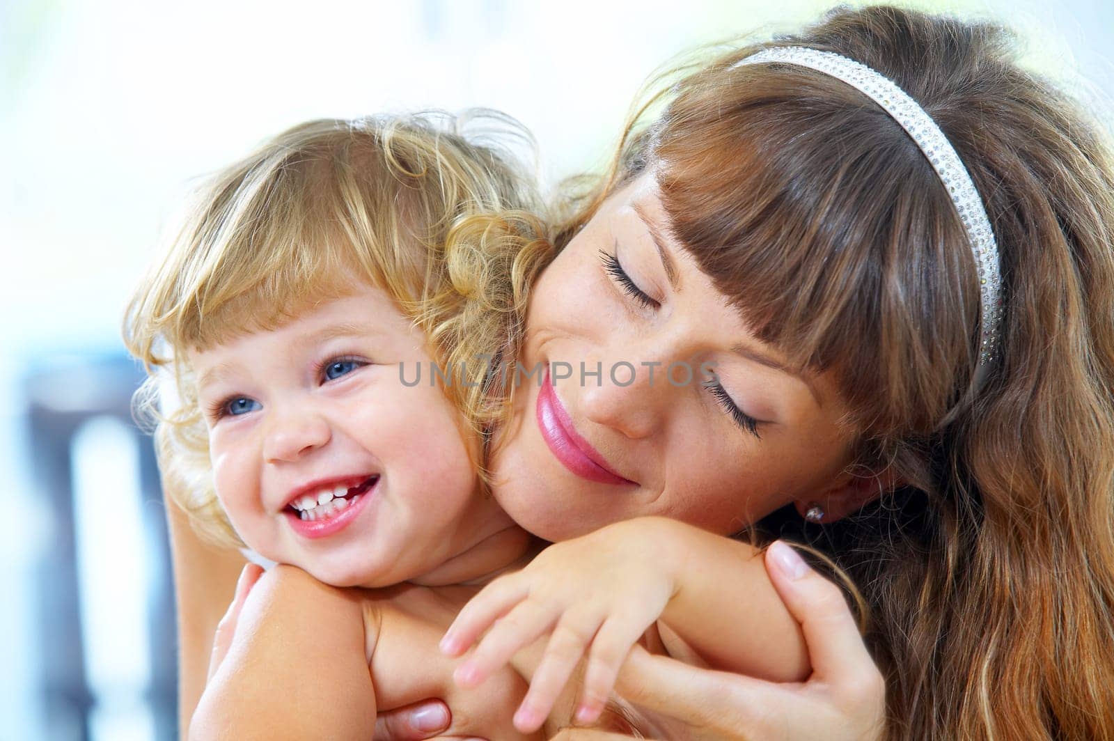 High key portrait of happy mother with baby