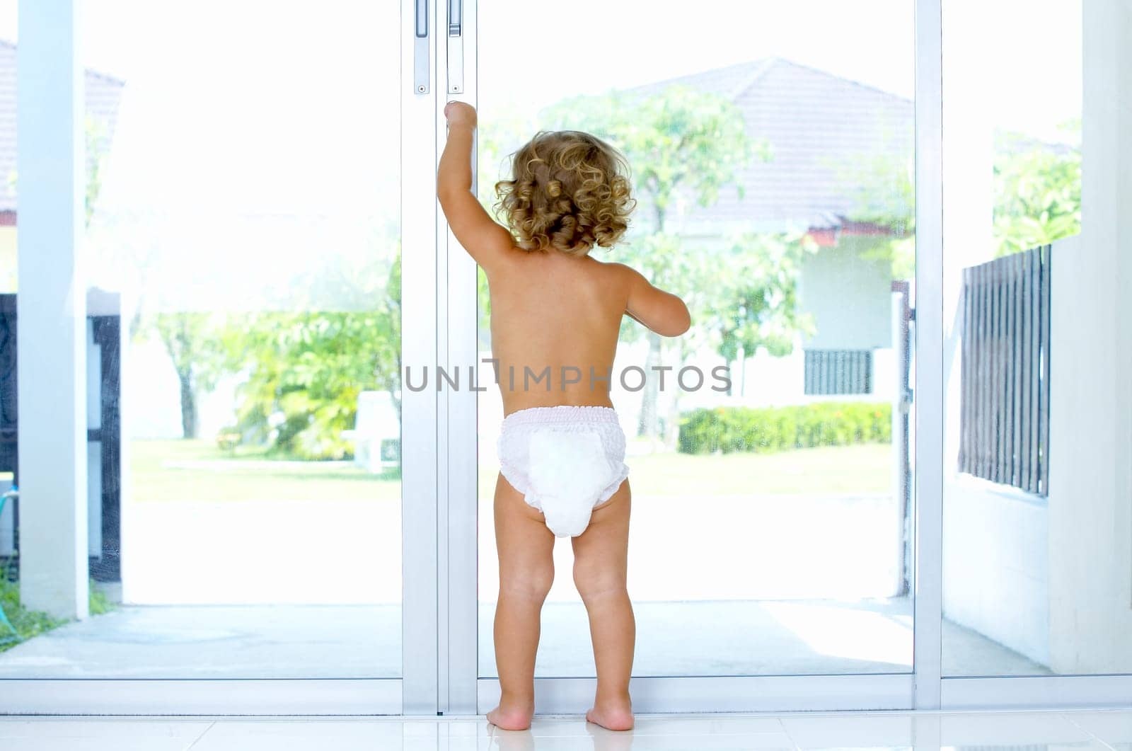 High key portrait of baby trying to get out of house