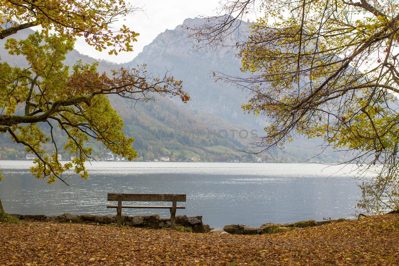autumn view of lake, trees and bench in Toscana Park, Gmunden, Austria