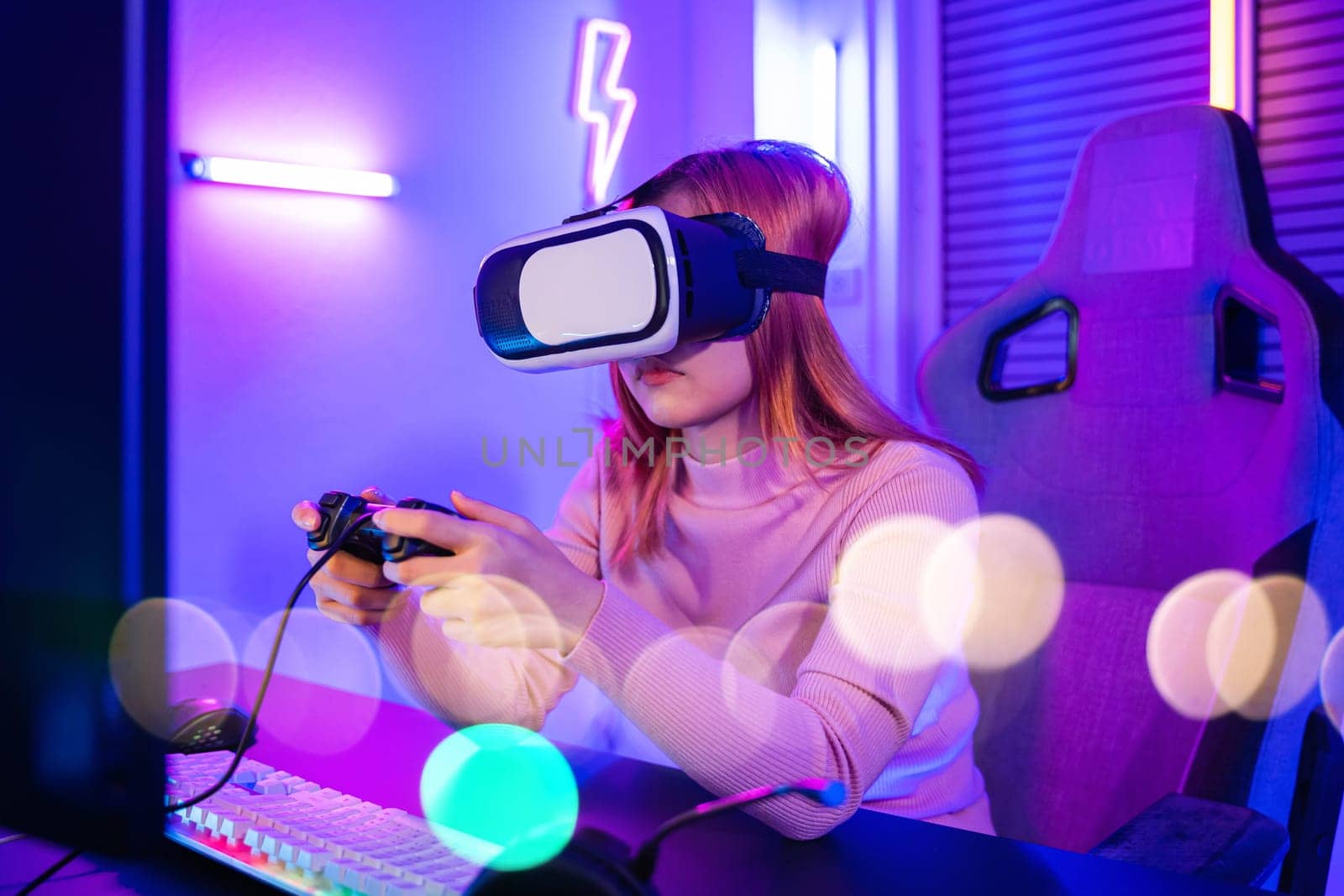 Excited woman virtual playing gamepad controller she very determined at home, Gamer in VR headset glasses exploring metaverse play video game online with joystick on computer neon lights