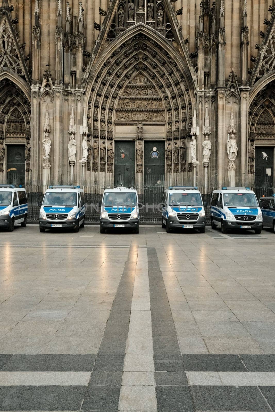 Row of Mercedes-Benz Sprinter police cars in front of Cologne Cathedral in Germany