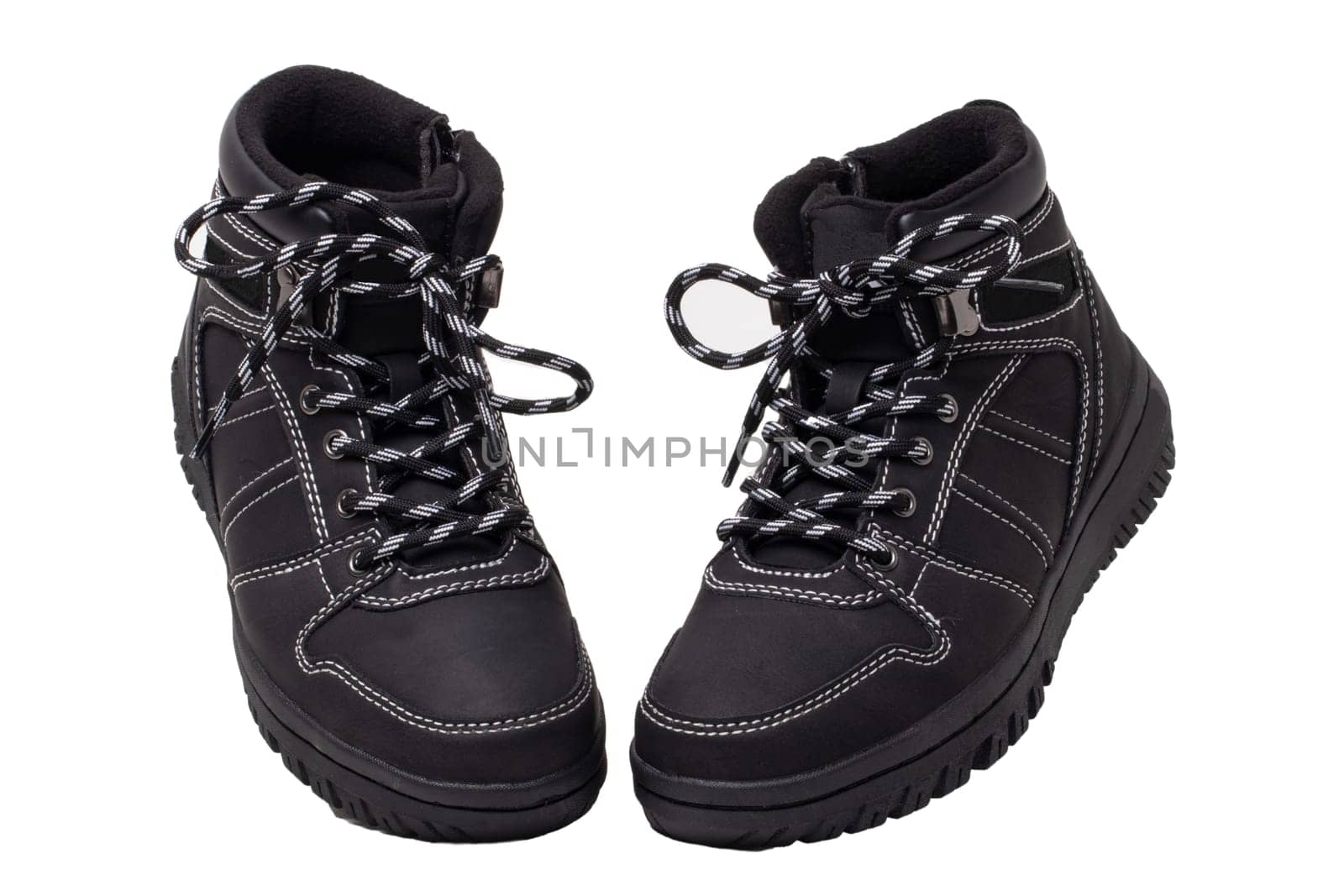 Winter boots. Close-up of a pair elegant black leather winter boots with laces and rivets isolated on white. Macro. Autumn shoe fashion for child boy.
