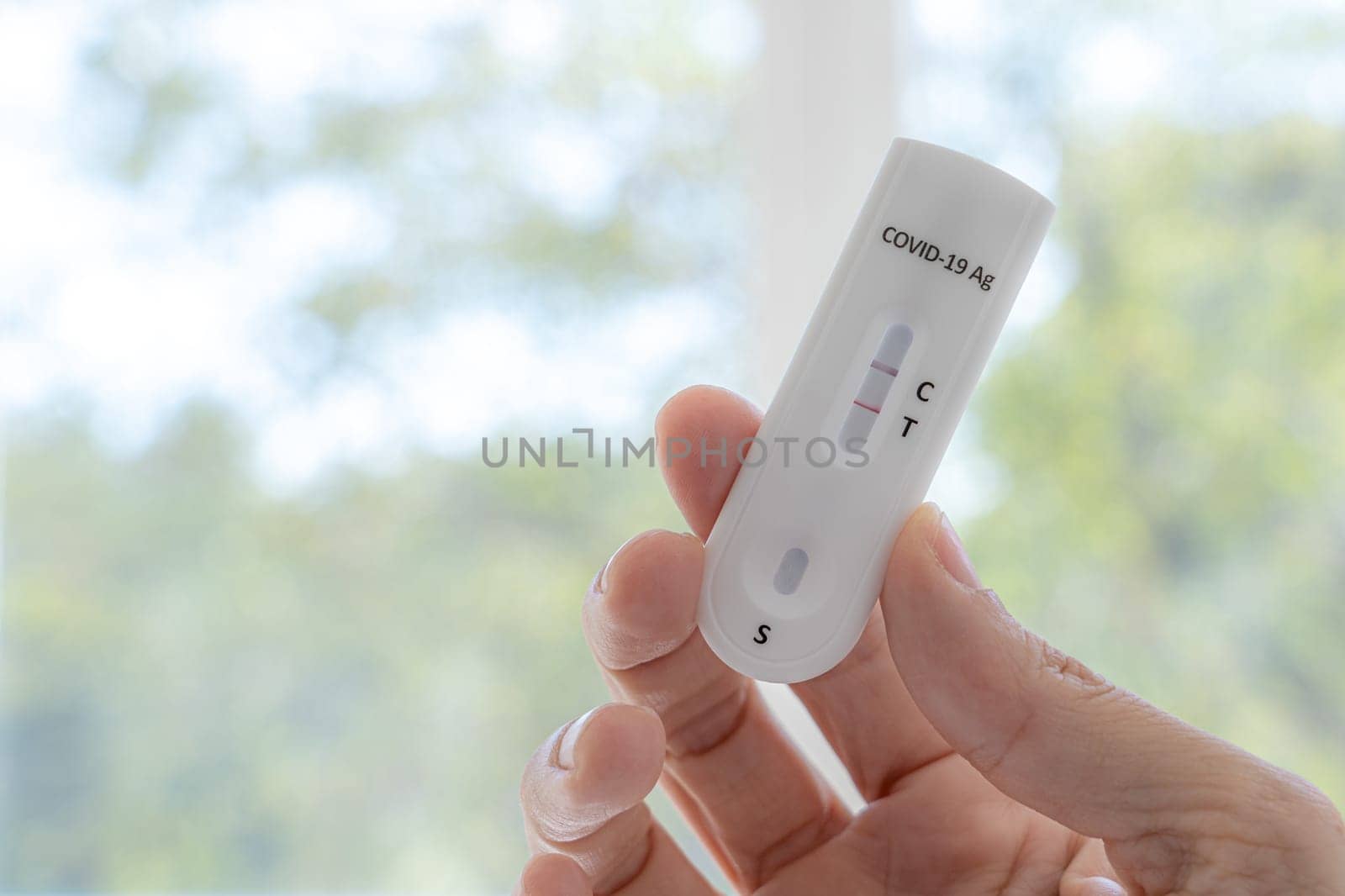 Coronavirus Covid-19 antigen test with positive result with human hand.