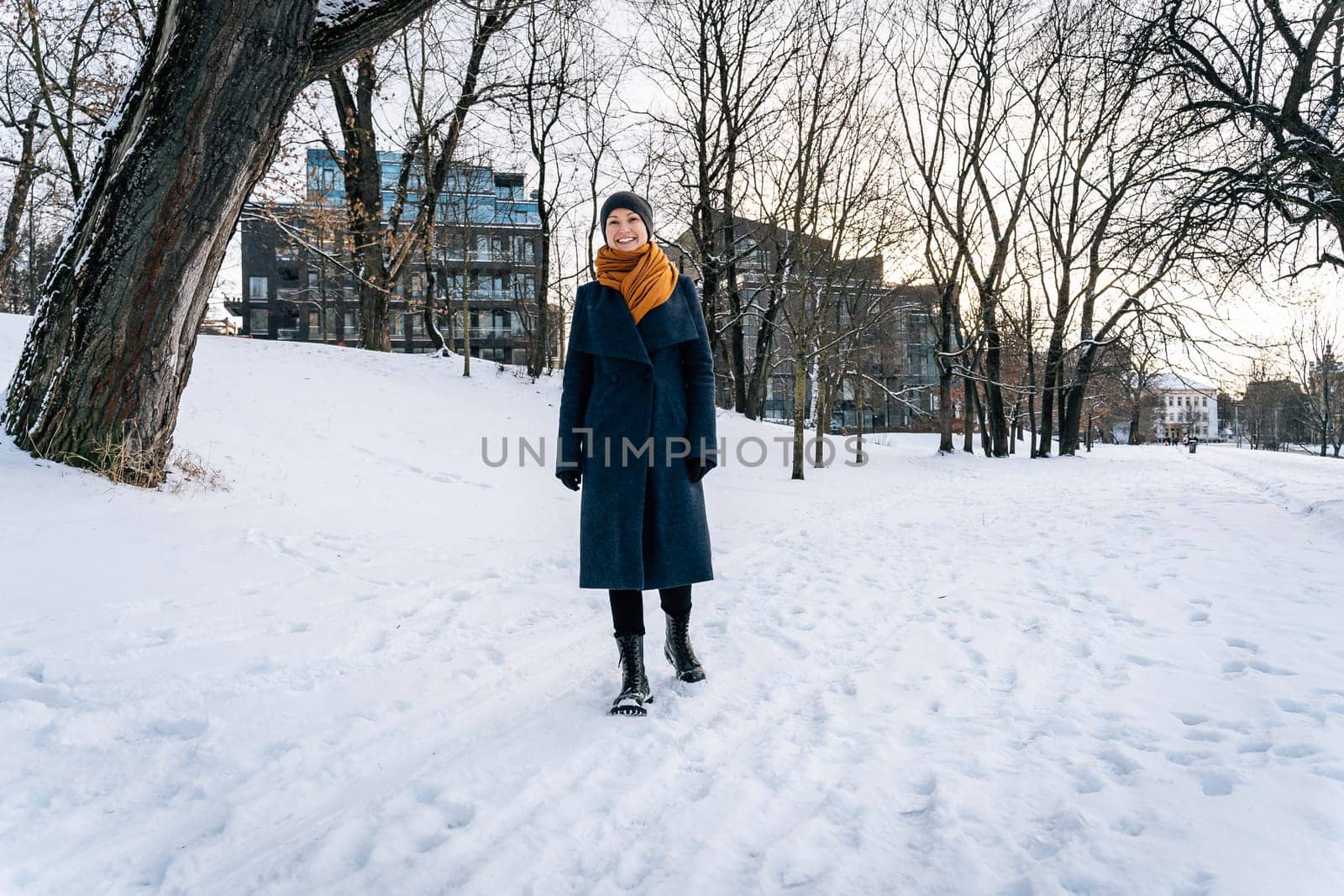 A cheerful young woman walks through a winter city.