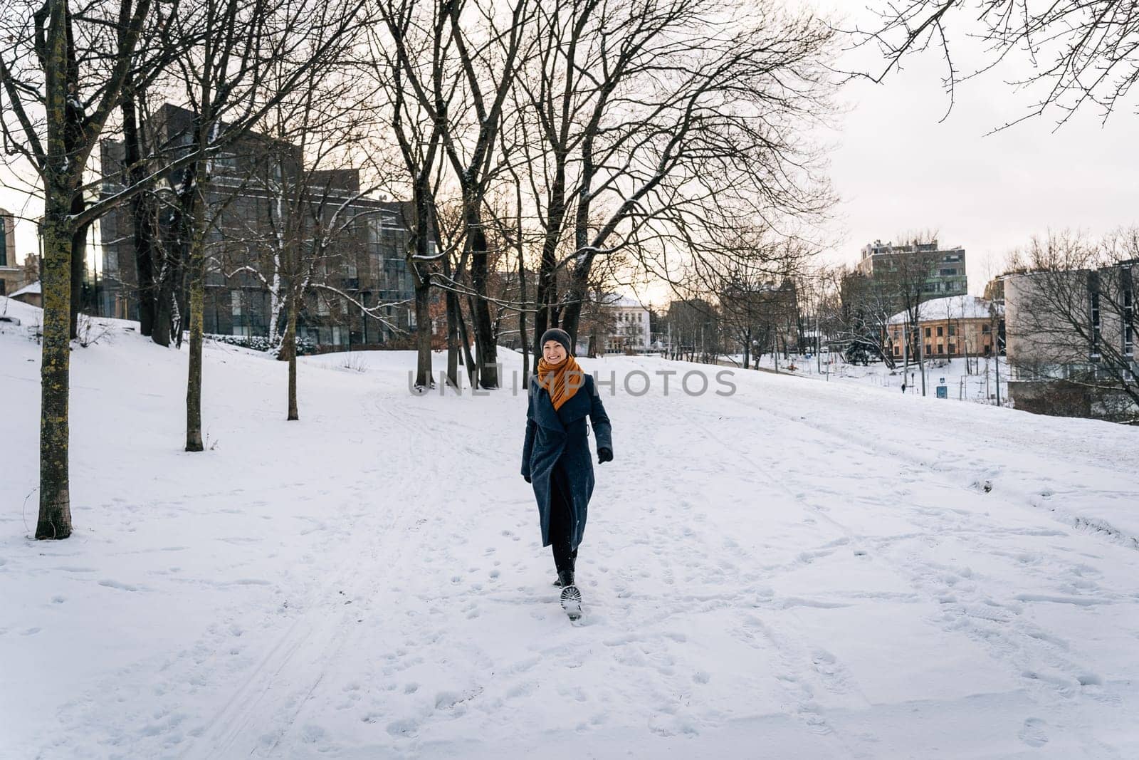 Wide viewing angle on a woman walking through a snowy winter city.