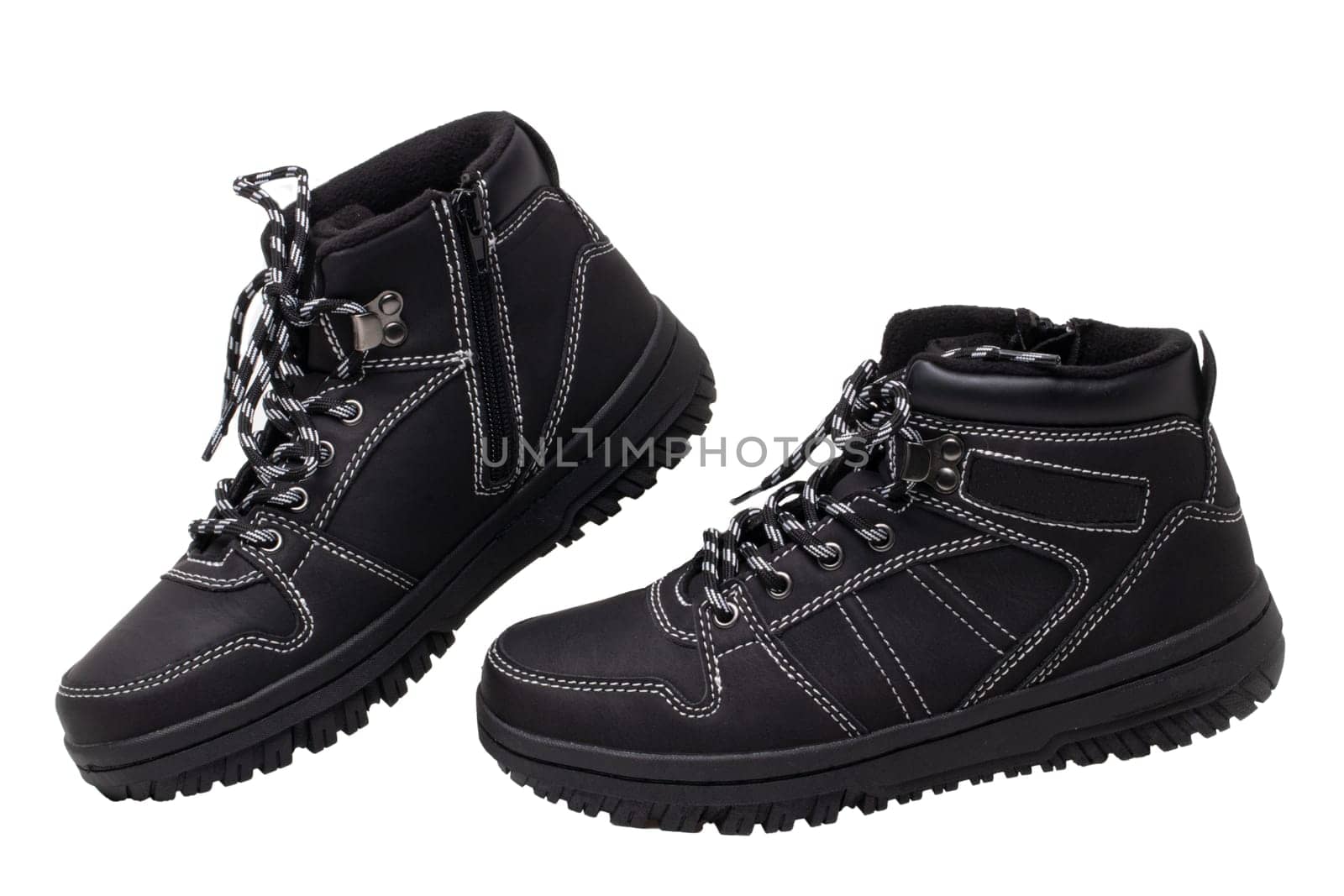 Winter boots. Close-up of a pair elegant black leather winter boots with laces and rivets isolated on white. Macro. Autumn shoe fashion for child boy.